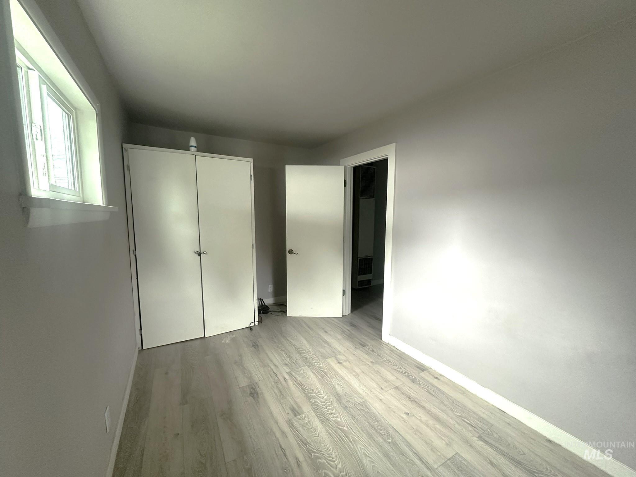 Unfurnished bedroom with light wood finished floors and a closet