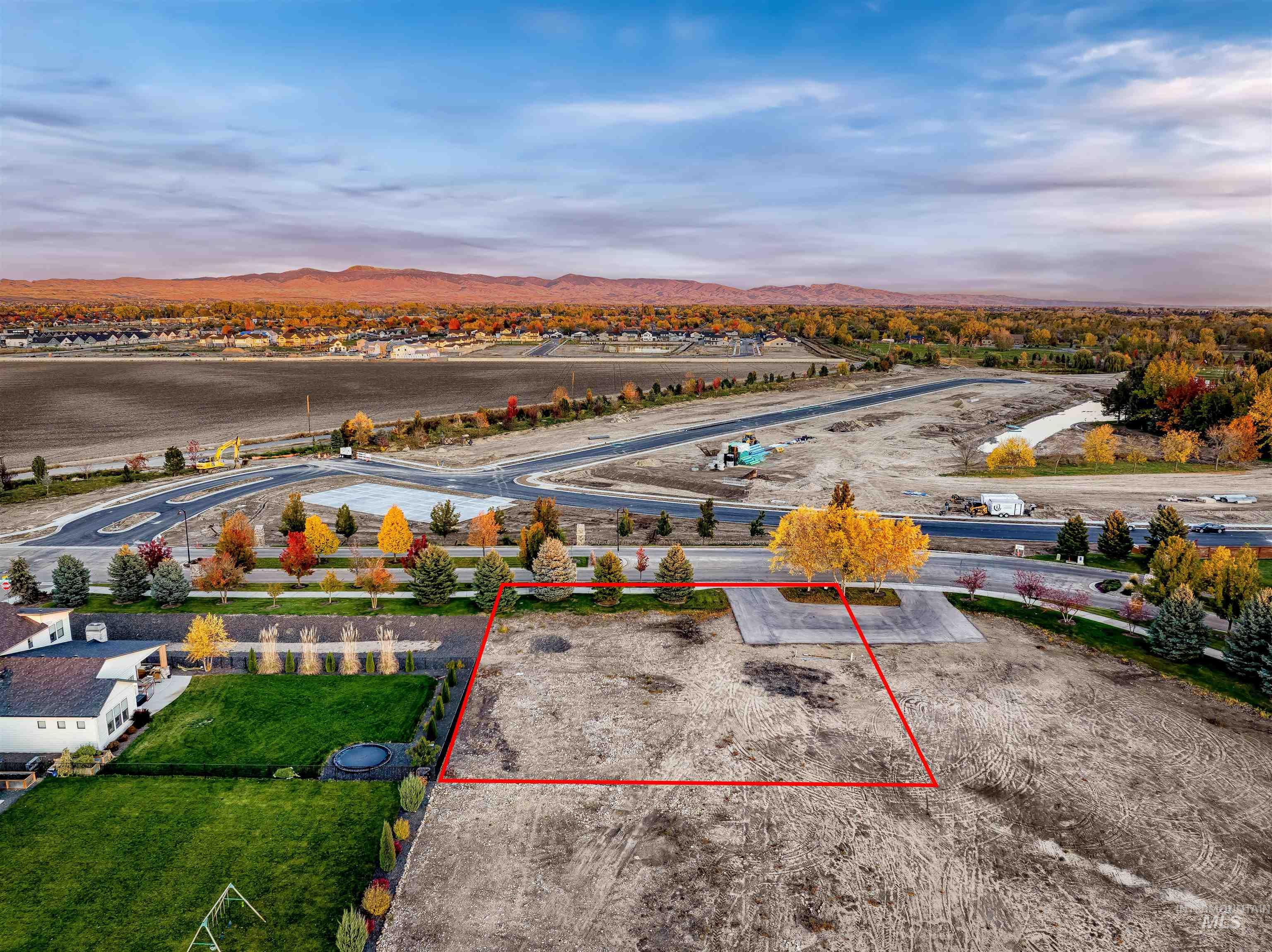 Aerial view of property and surrounding area with property boundaries highlighted and a mountainous background
