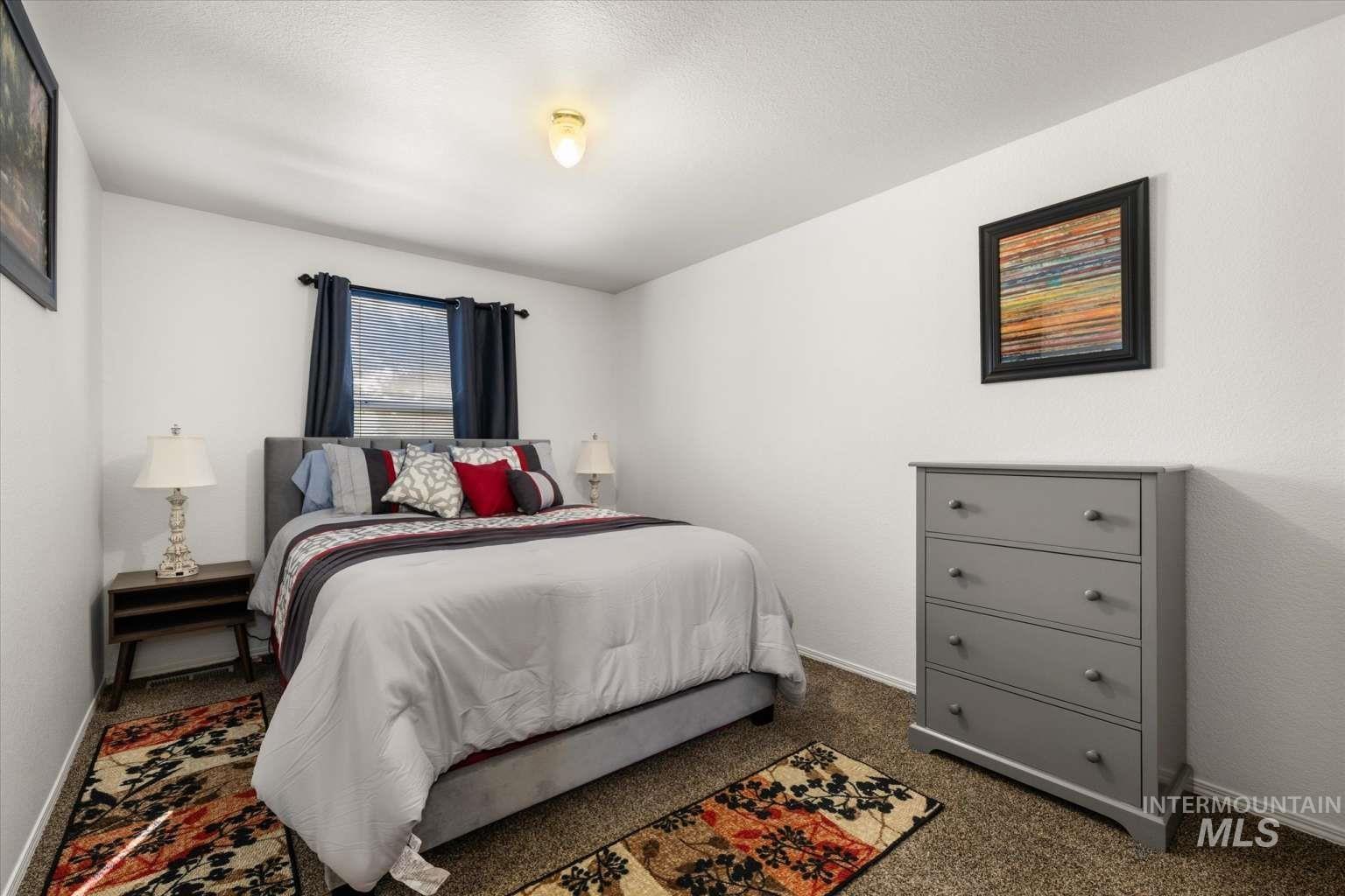 Carpeted bedroom with baseboards and a textured ceiling