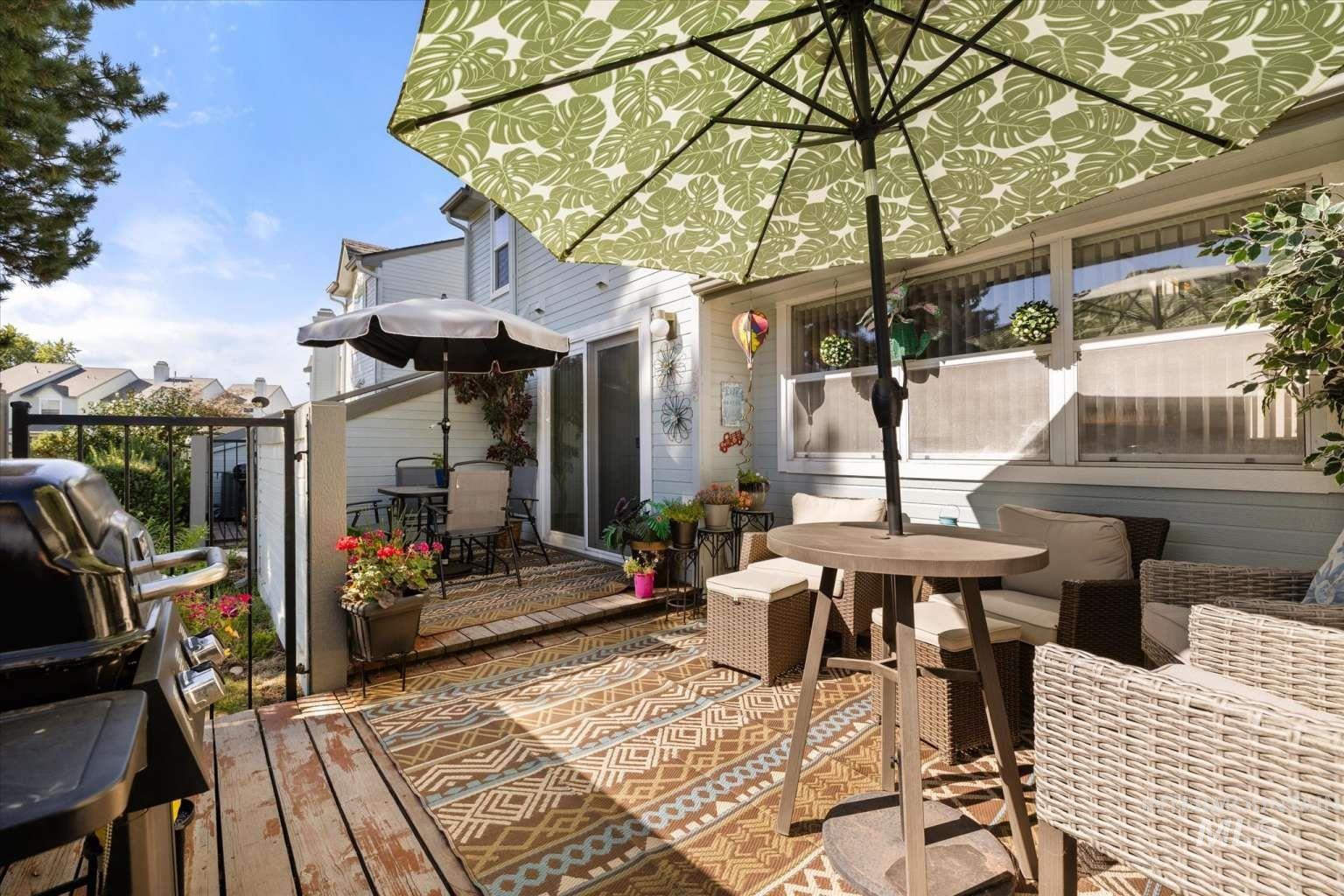 Wooden terrace featuring outdoor dining area and a grill