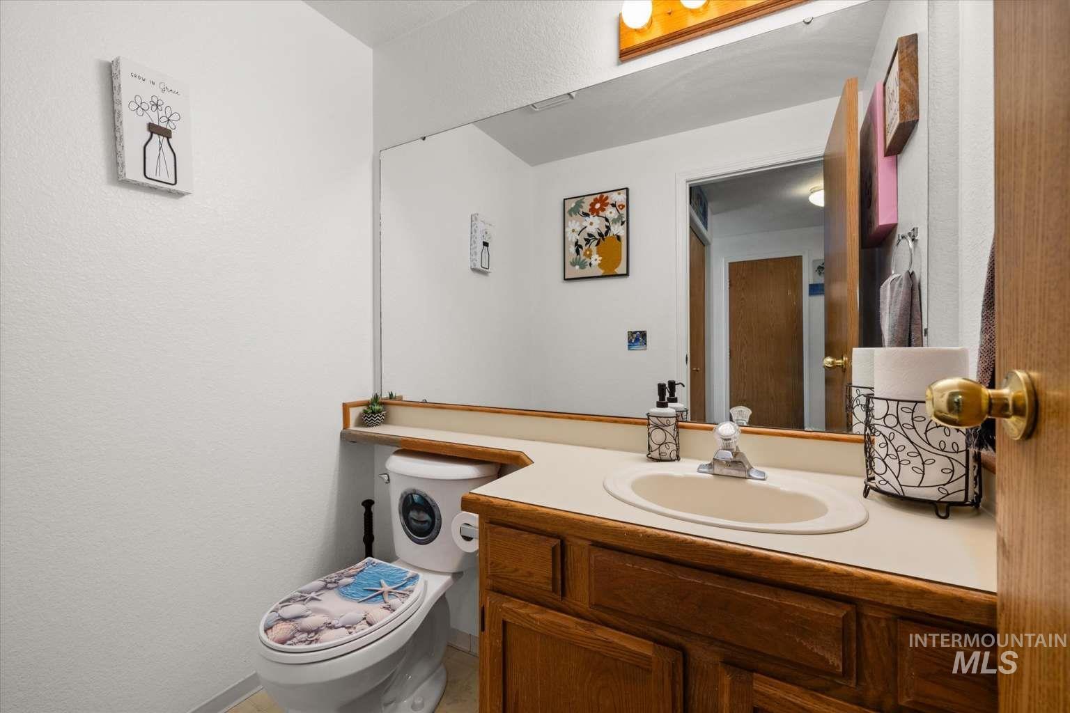 Half bathroom featuring vanity and a textured wall