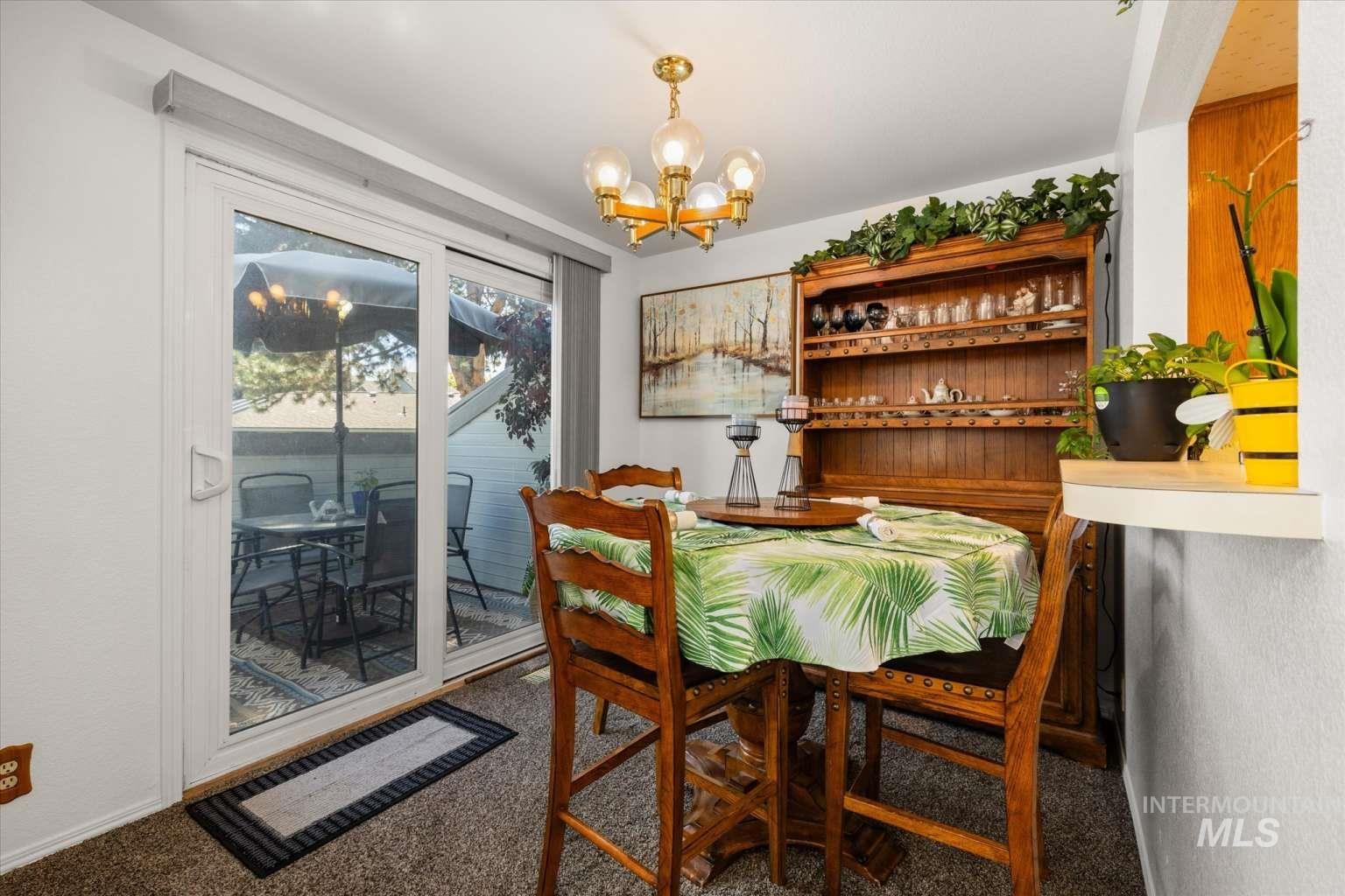 Carpeted dining area featuring a chandelier