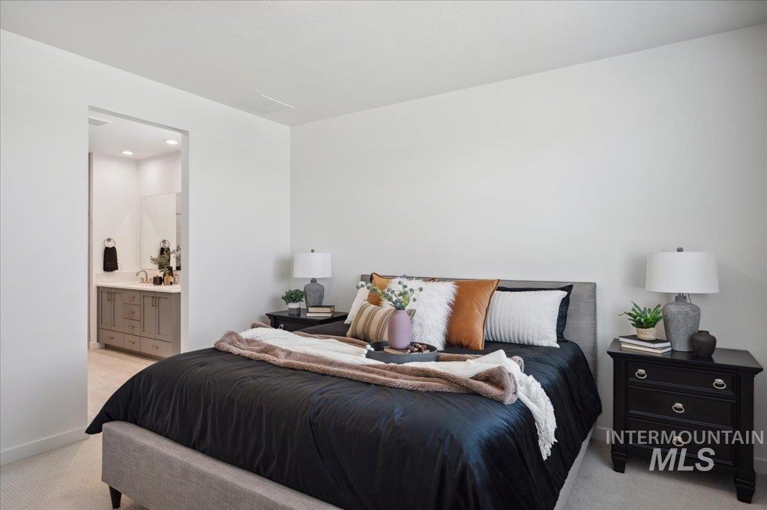 Carpeted bedroom with baseboards and ensuite bath