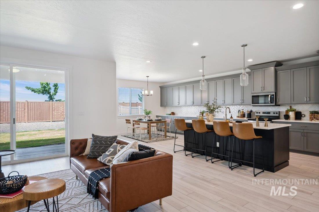 Living area featuring light wood-type flooring, a chandelier, and recessed lighting