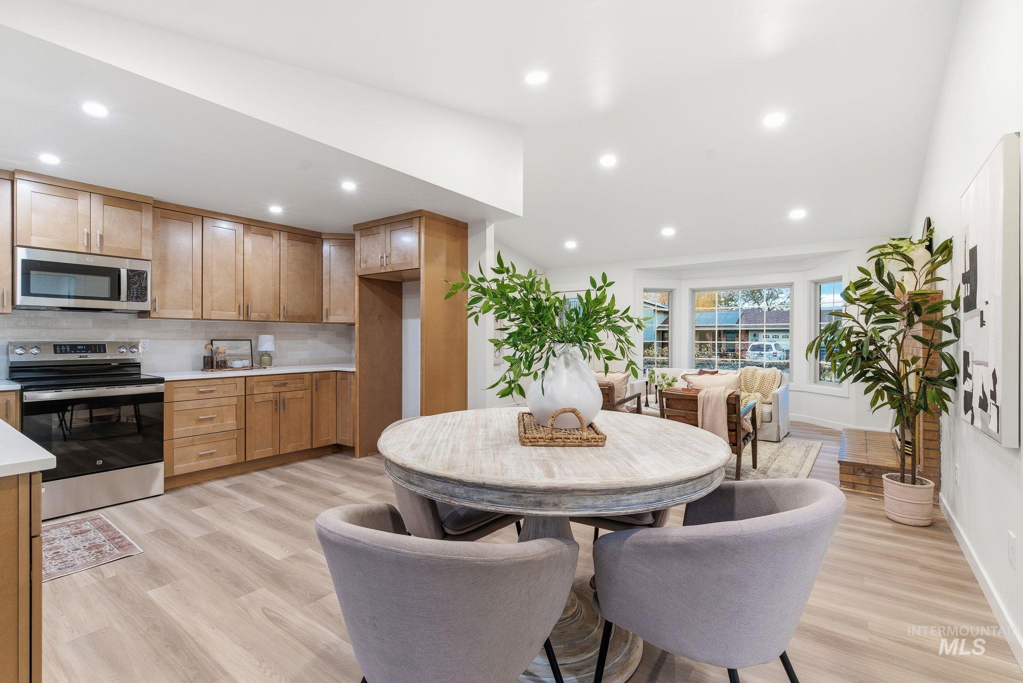 Kitchen with stainless steel appliances, tasteful backsplash, light wood-type flooring, recessed lighting, and brown cabinetry