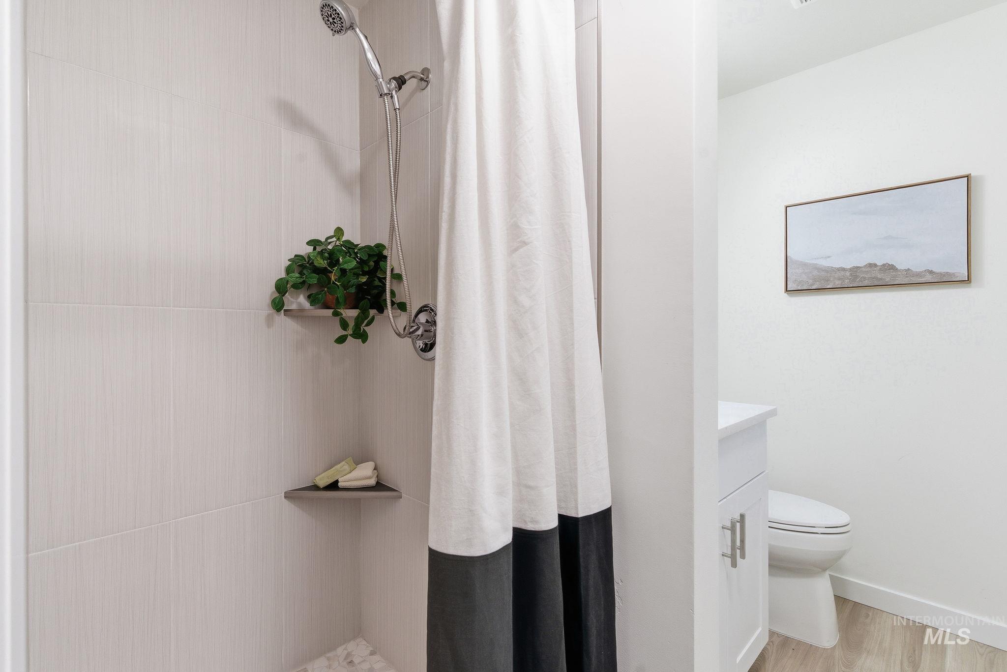 Bathroom with a shower stall, vanity, and light wood finished floors