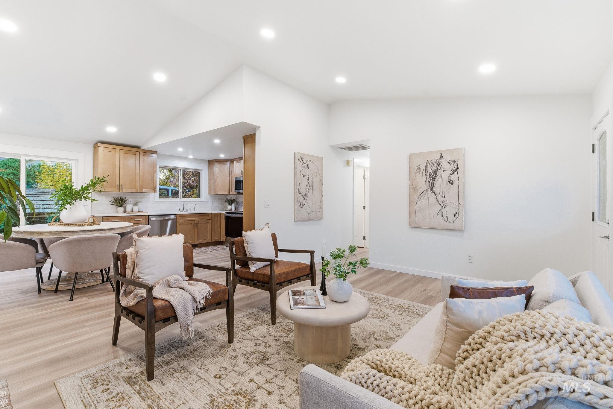 Living area with vaulted ceiling, recessed lighting, and light wood finished floors