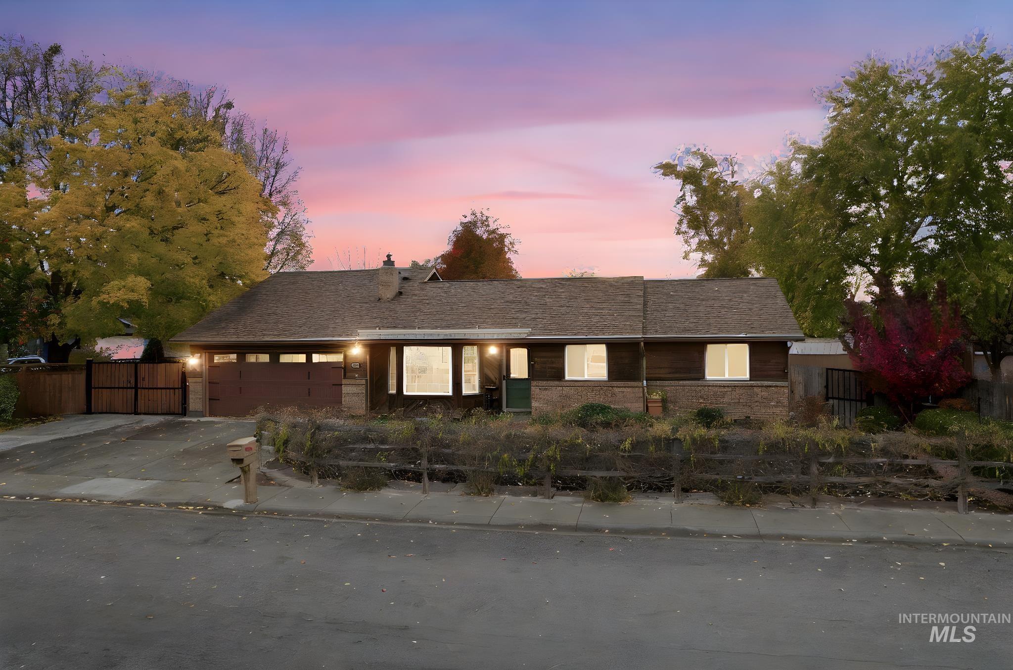 Single story home featuring concrete driveway, an attached garage, and a shingled roof