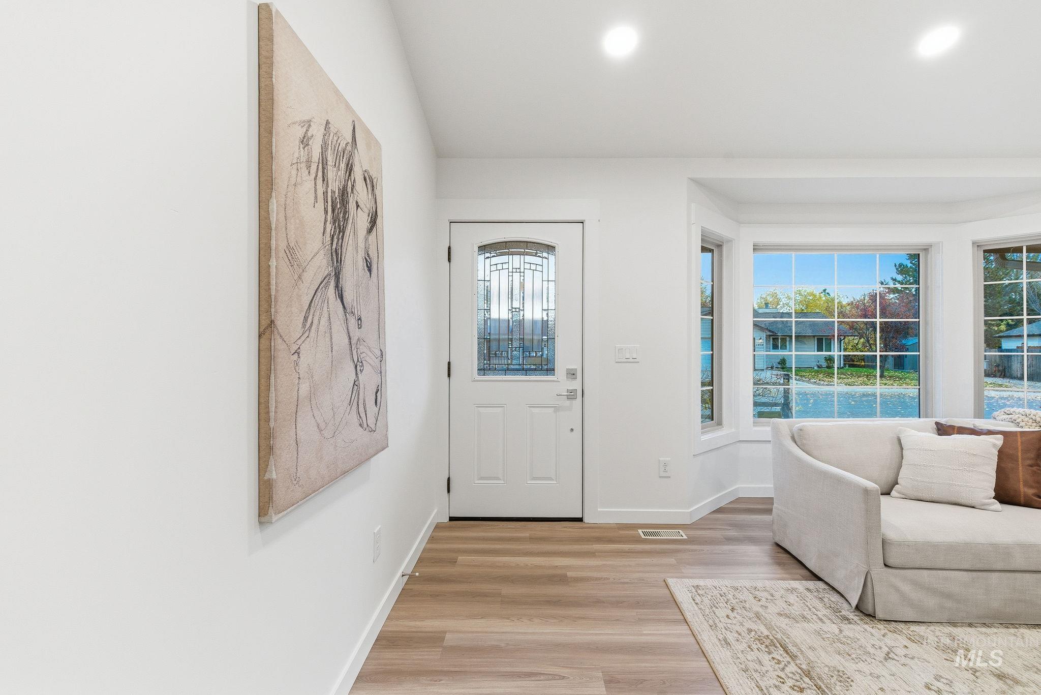 Entrance foyer with light wood-style floors and recessed lighting