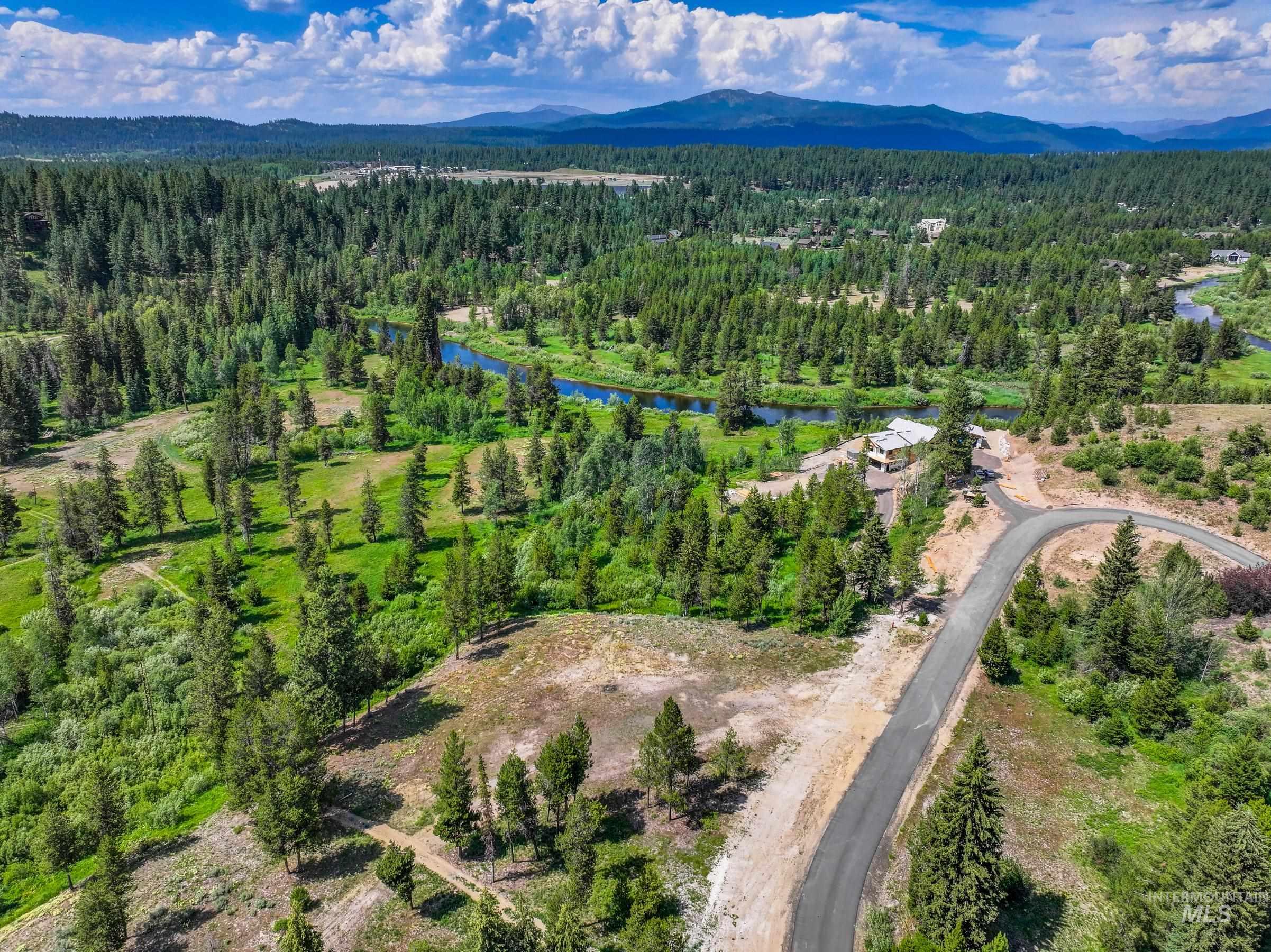 Aerial view of property's location featuring a heavily wooded area and a water and mountain view
