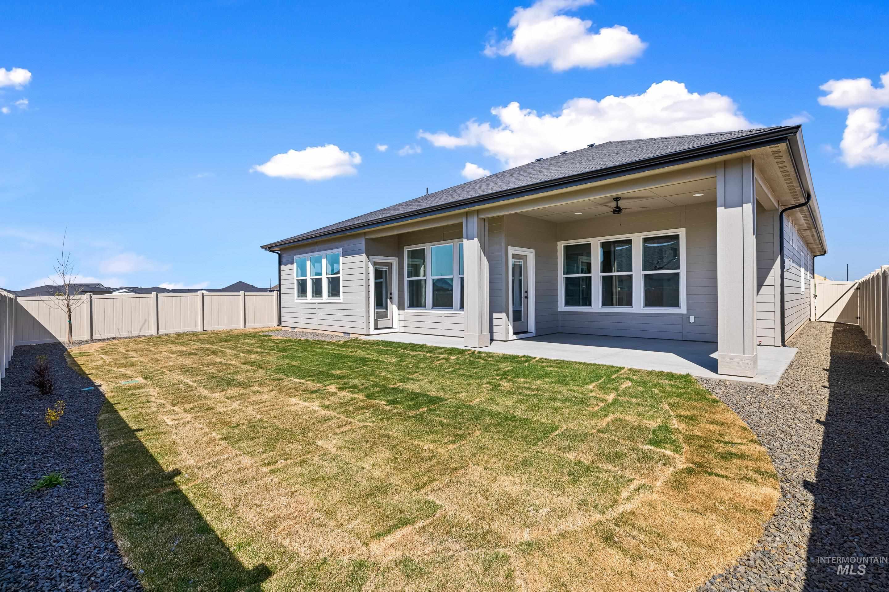Rear view of house featuring a patio area, a fenced backyard, a ceiling fan, and roof with shingles
