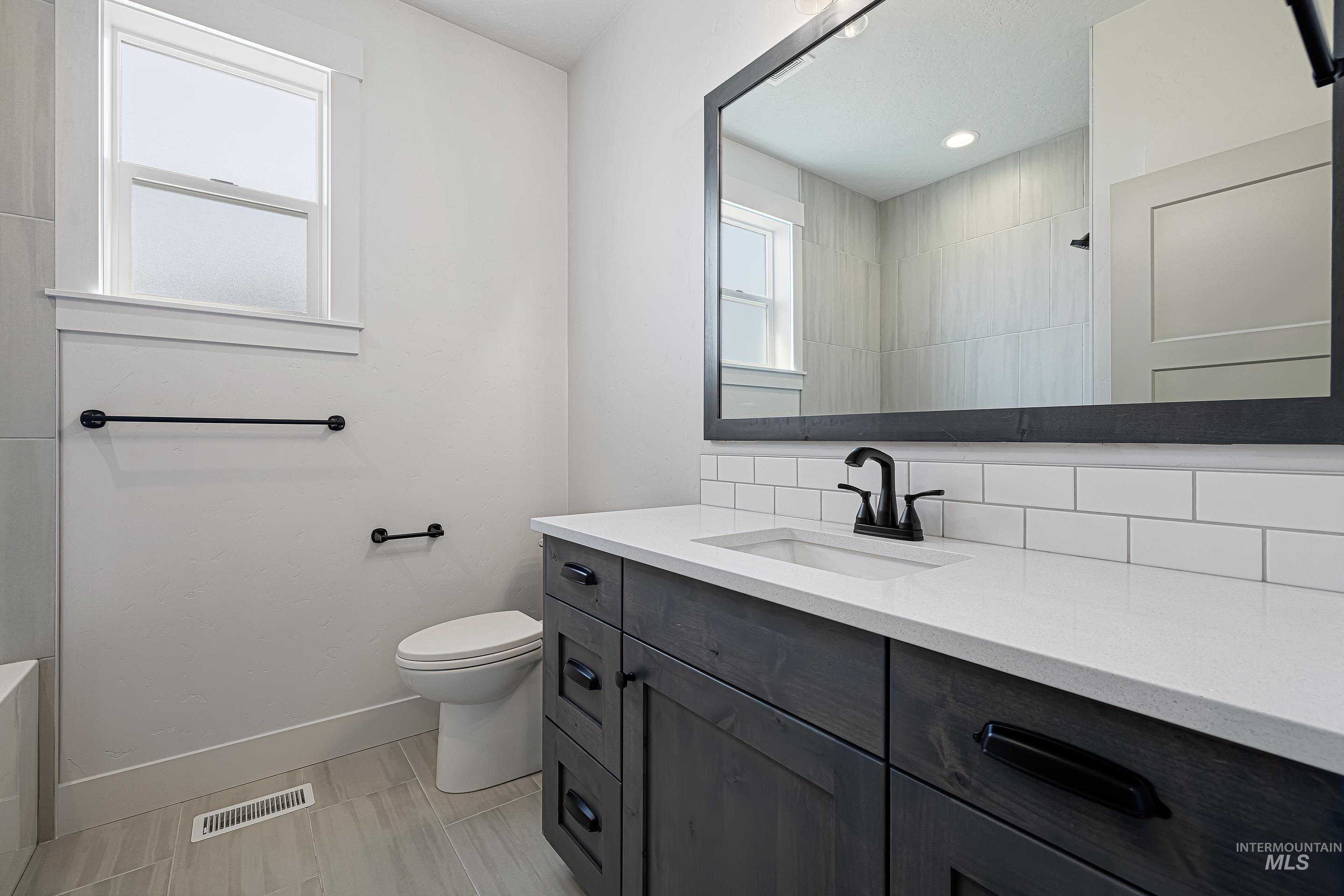 Bathroom featuring vanity, a shower, and recessed lighting