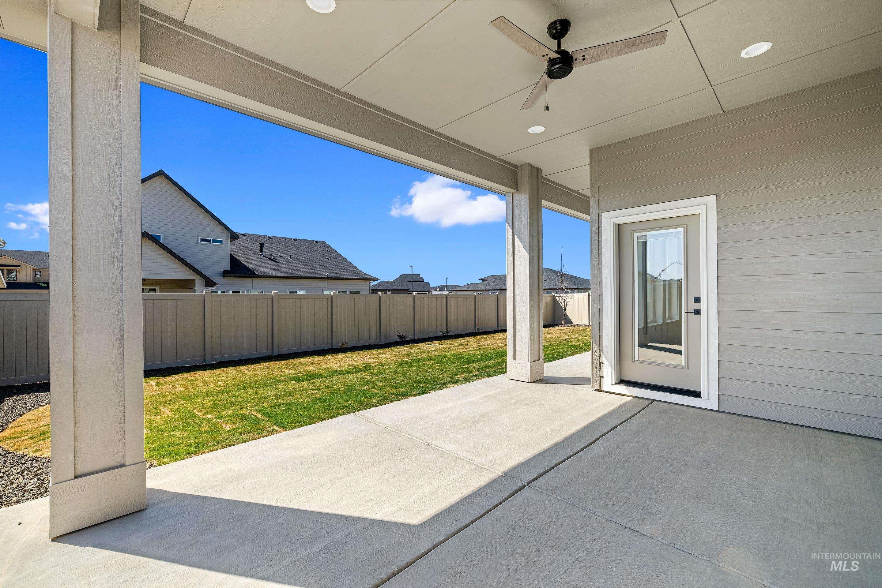 Fenced backyard featuring a patio and a ceiling fan