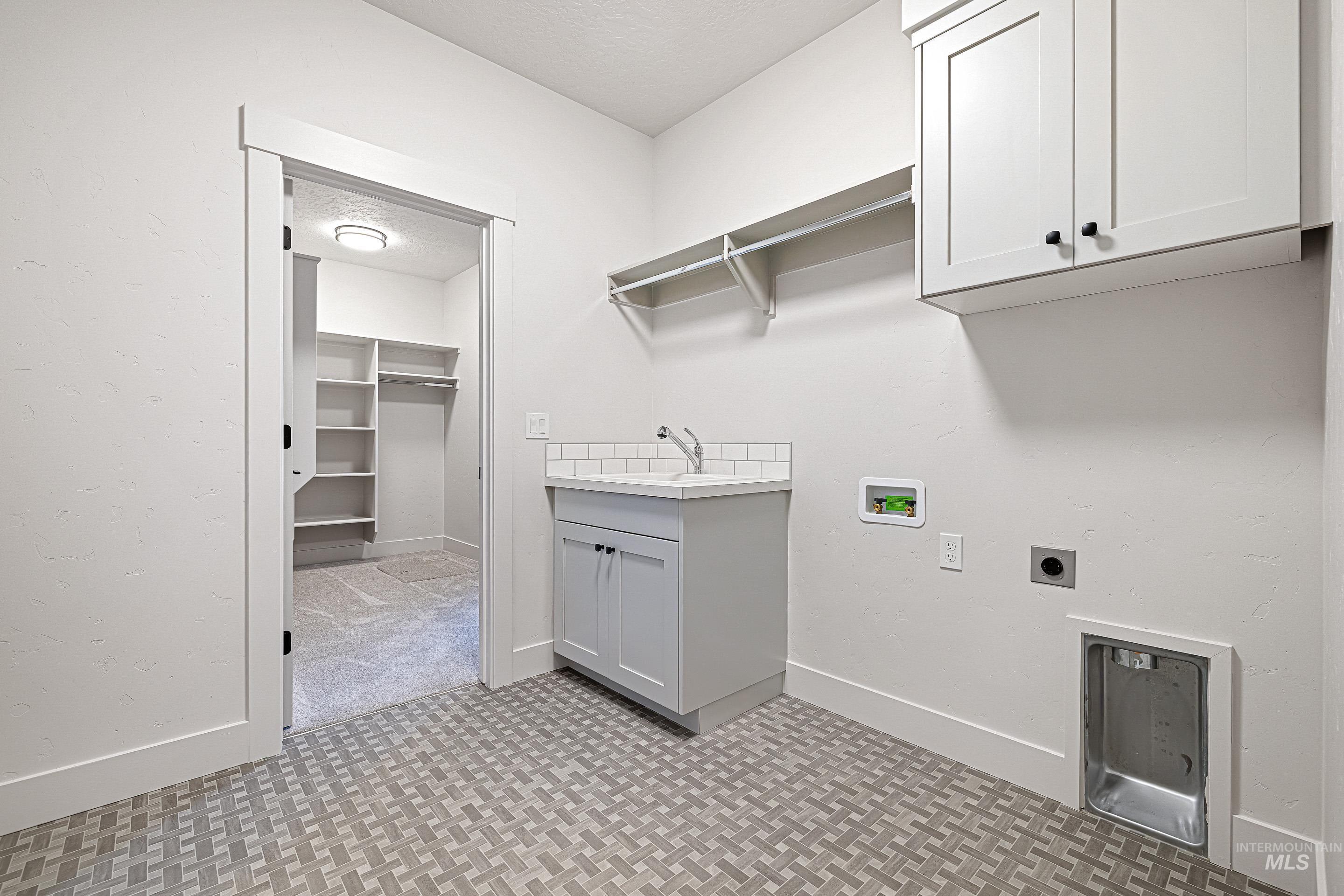 Laundry area featuring cabinet space, hookup for an electric dryer, washer hookup, and a textured ceiling