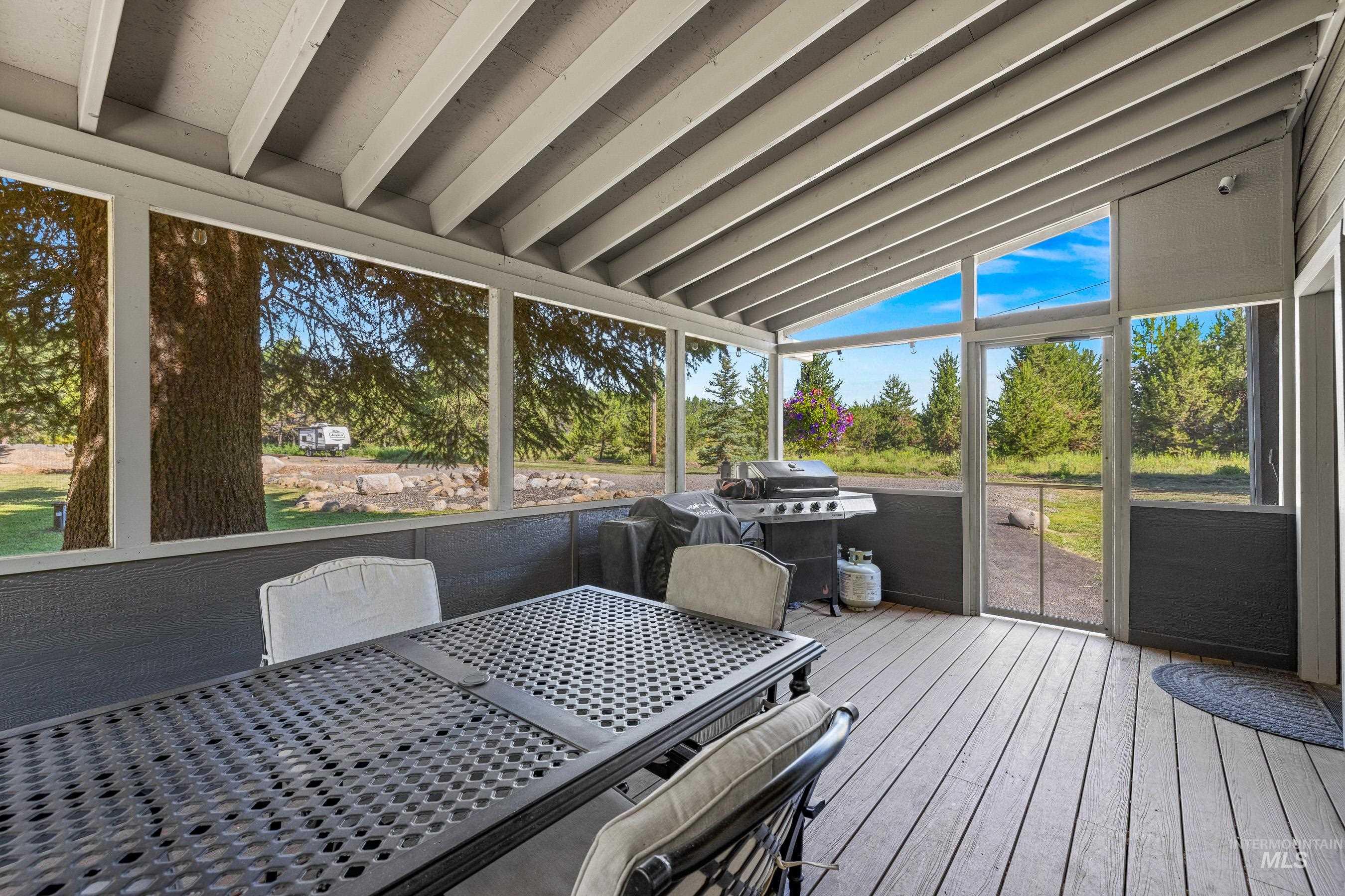 Sunroom with lofted ceiling and outdoor dining area