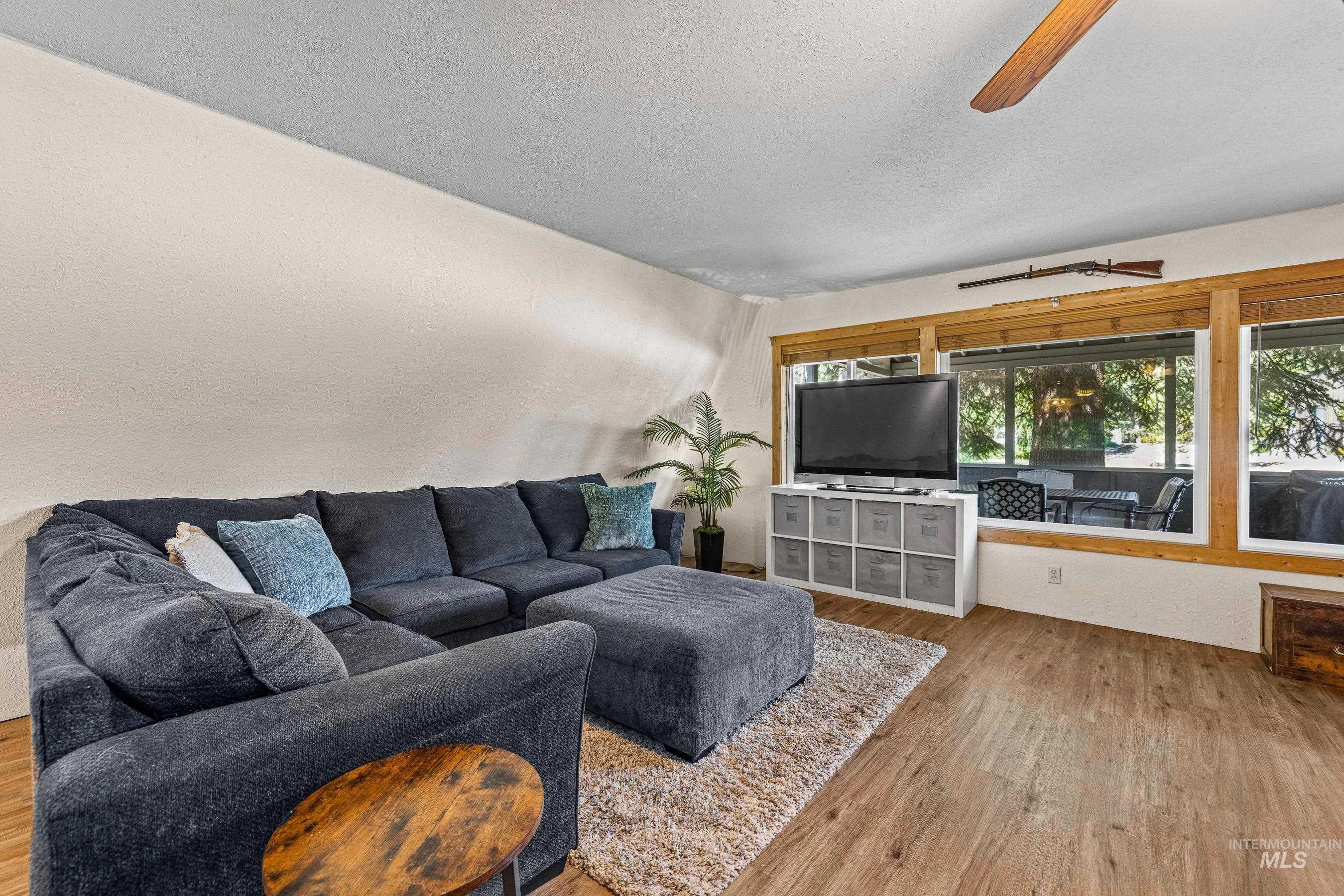 Living area featuring LVP flooring, textured ceiling, and ceiling fan
