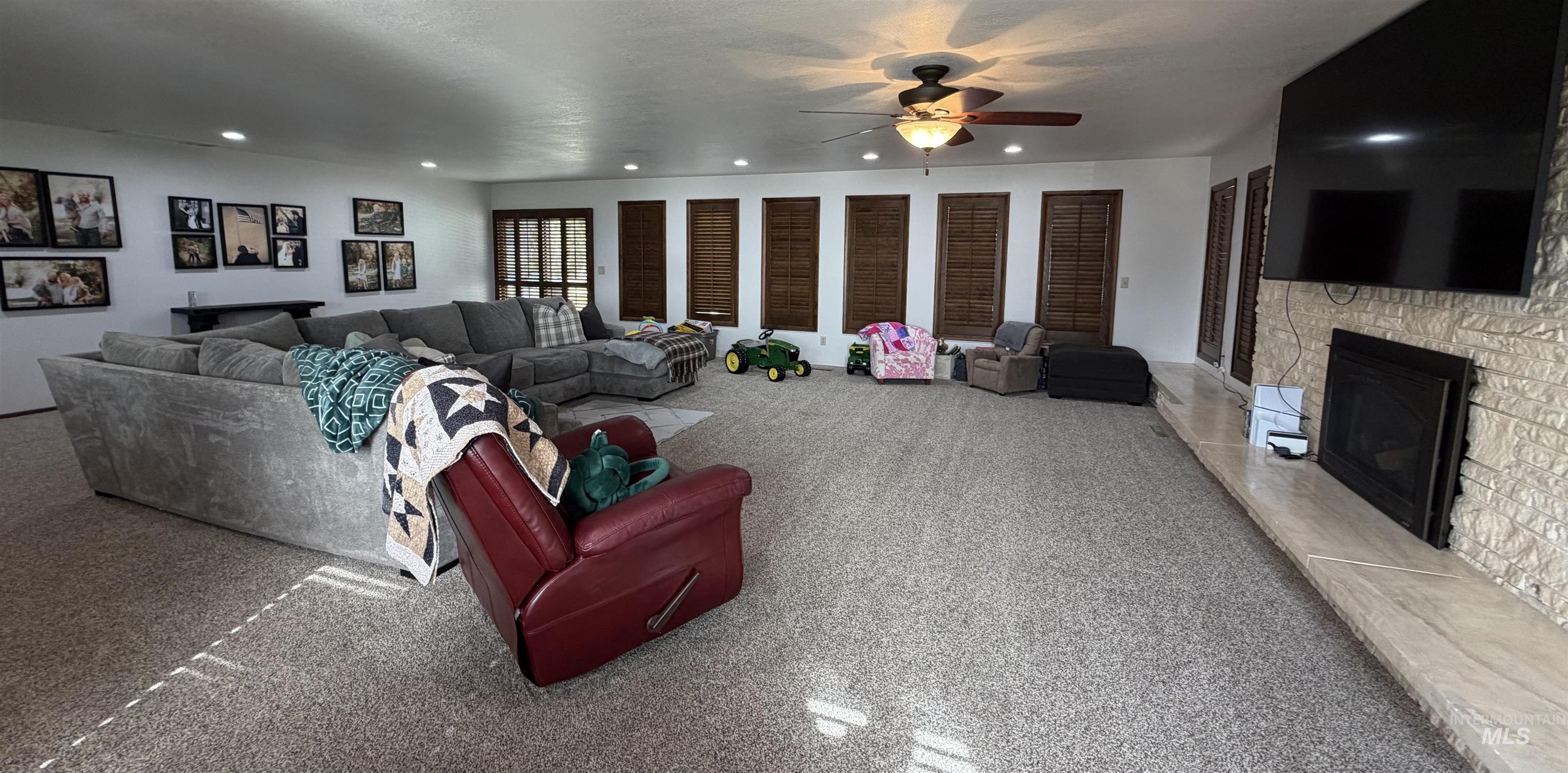 Spacious living area featuring carpeted flooring and recessed lighting