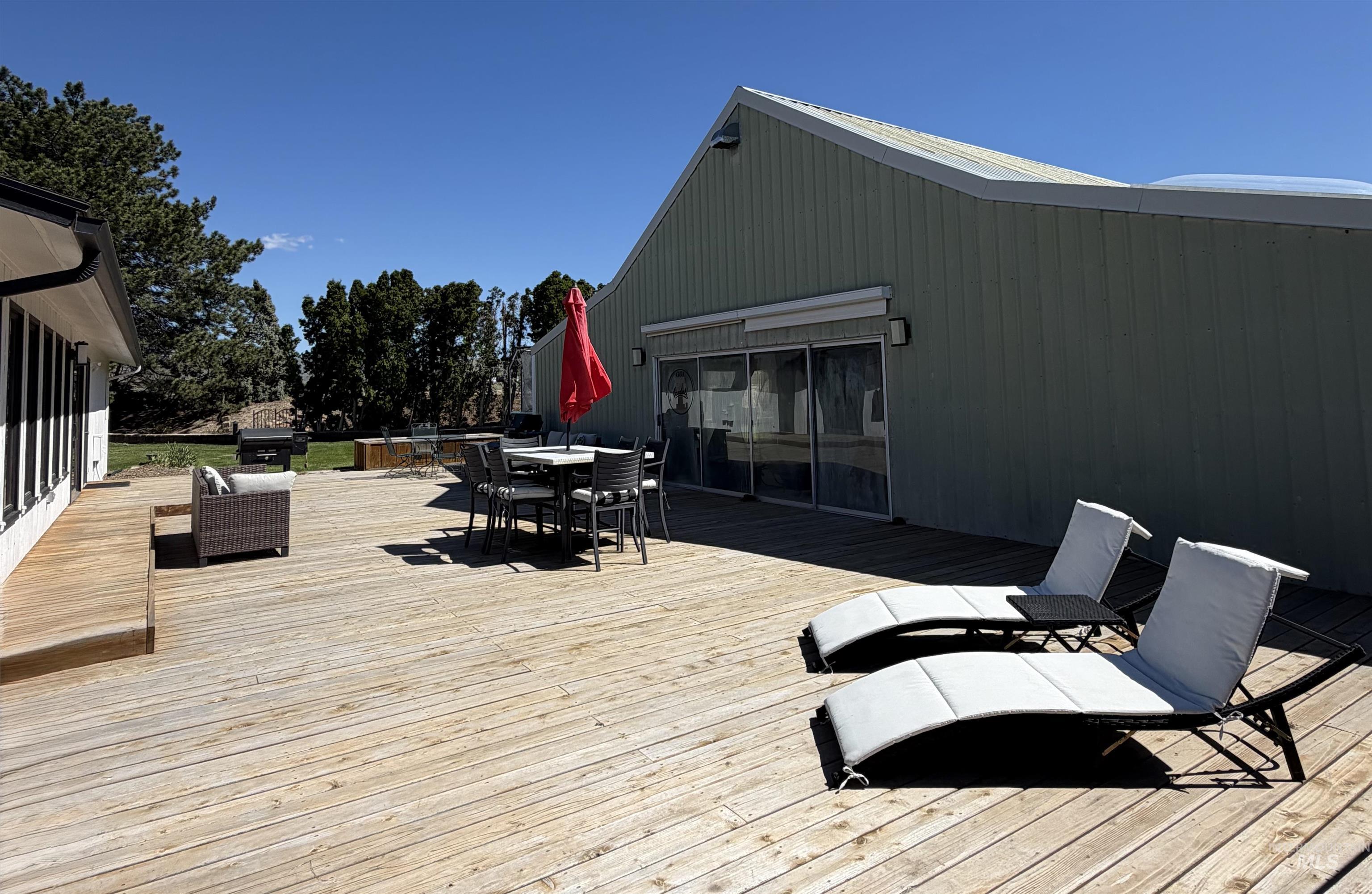 Expansive wood deck with a partial elevated section, offering multiple areas for outdoor activities