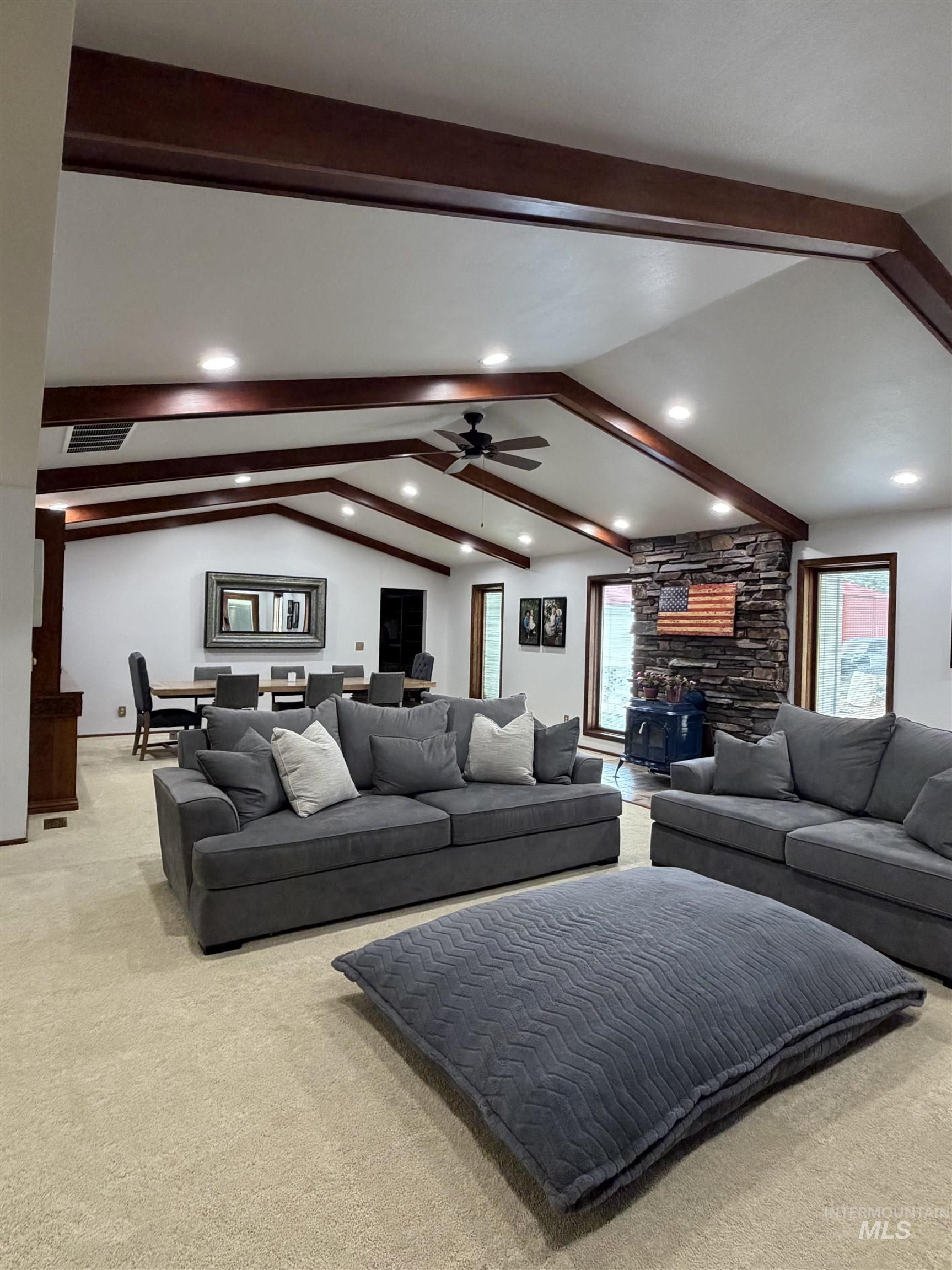 Vaulted ceiling with exposed wood beams and recessed lighting
