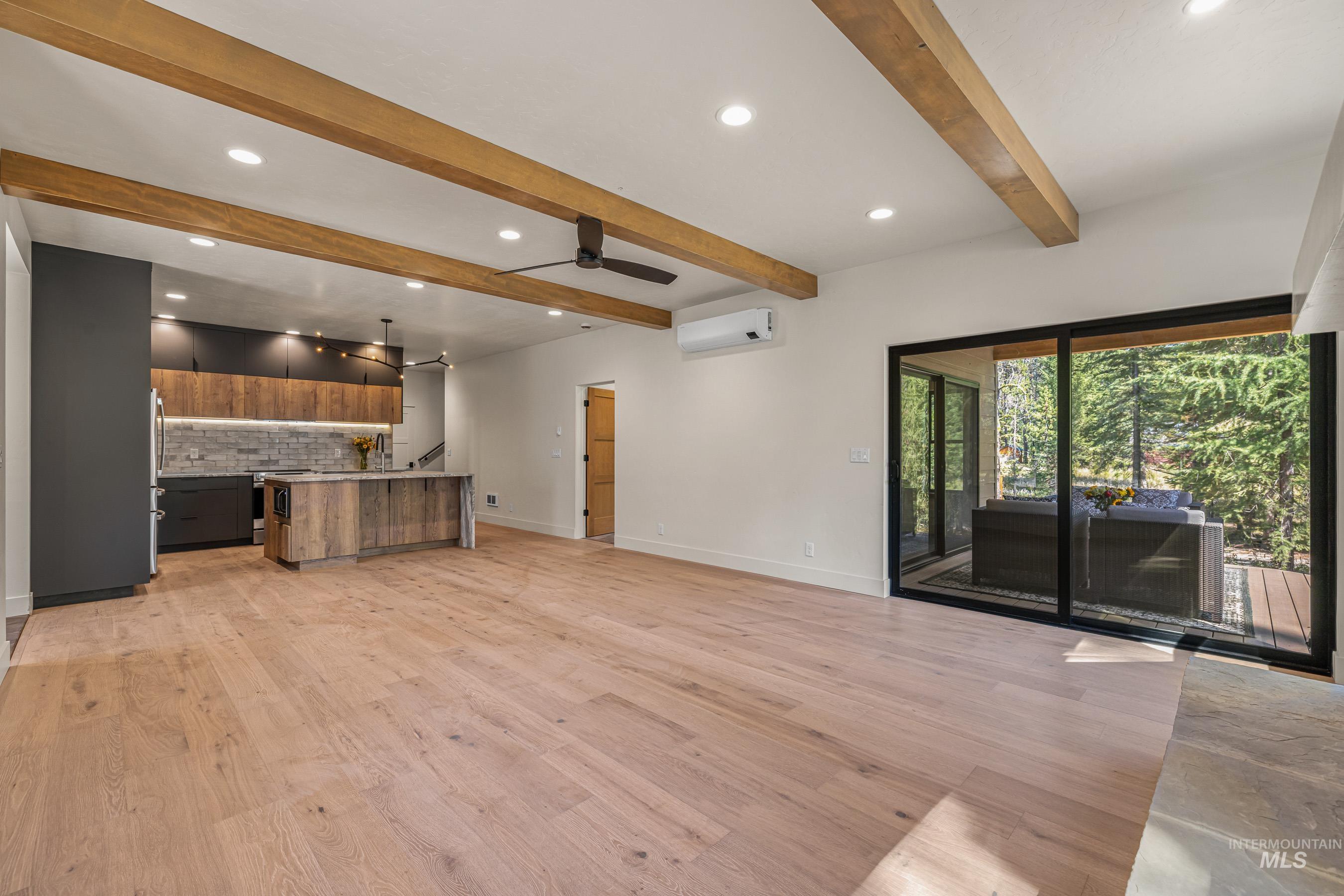 Unfurnished living room featuring recessed lighting, light wood finished floors, beamed ceiling, and a ceiling fan