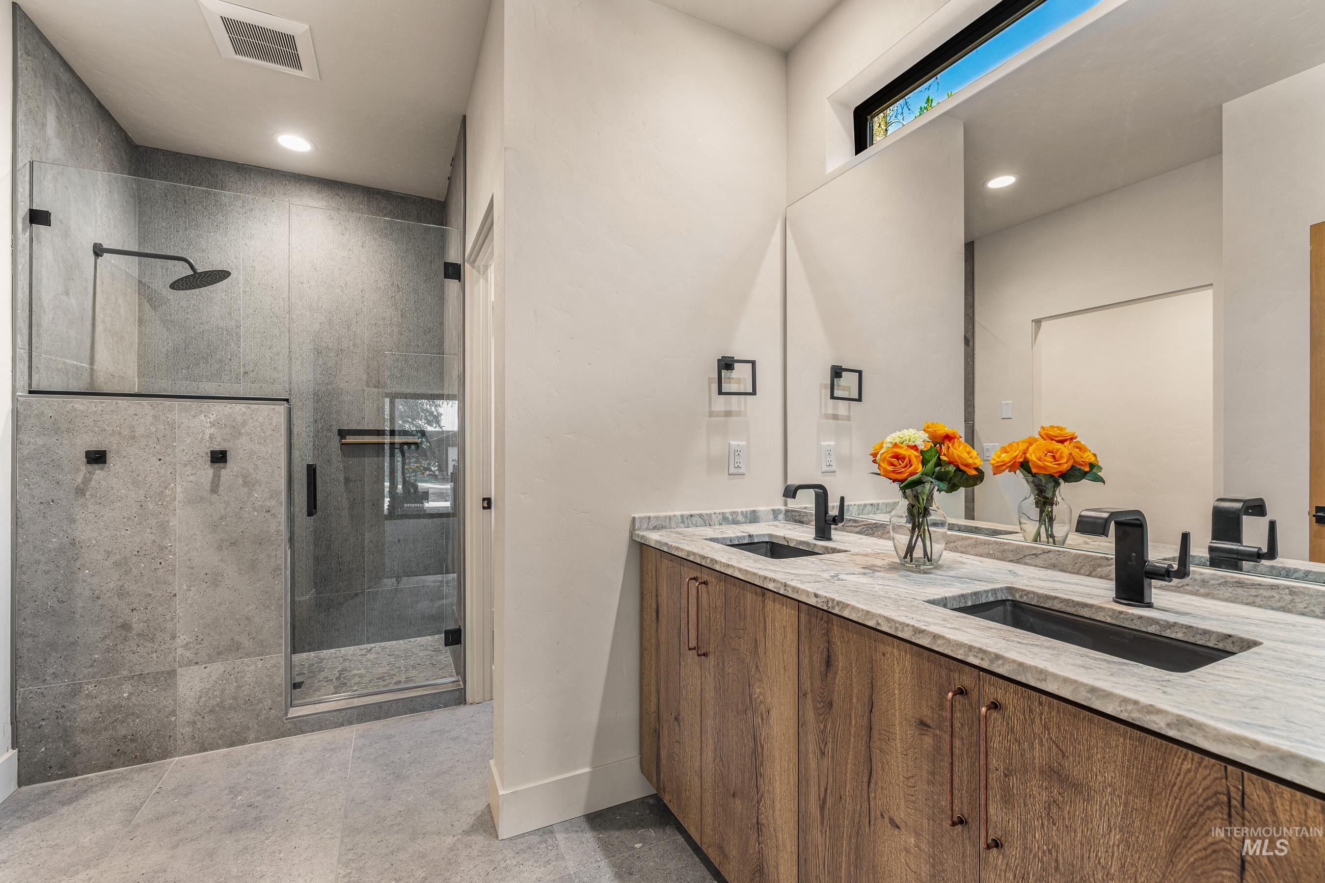 Full bath featuring double vanity, a shower stall, and recessed lighting