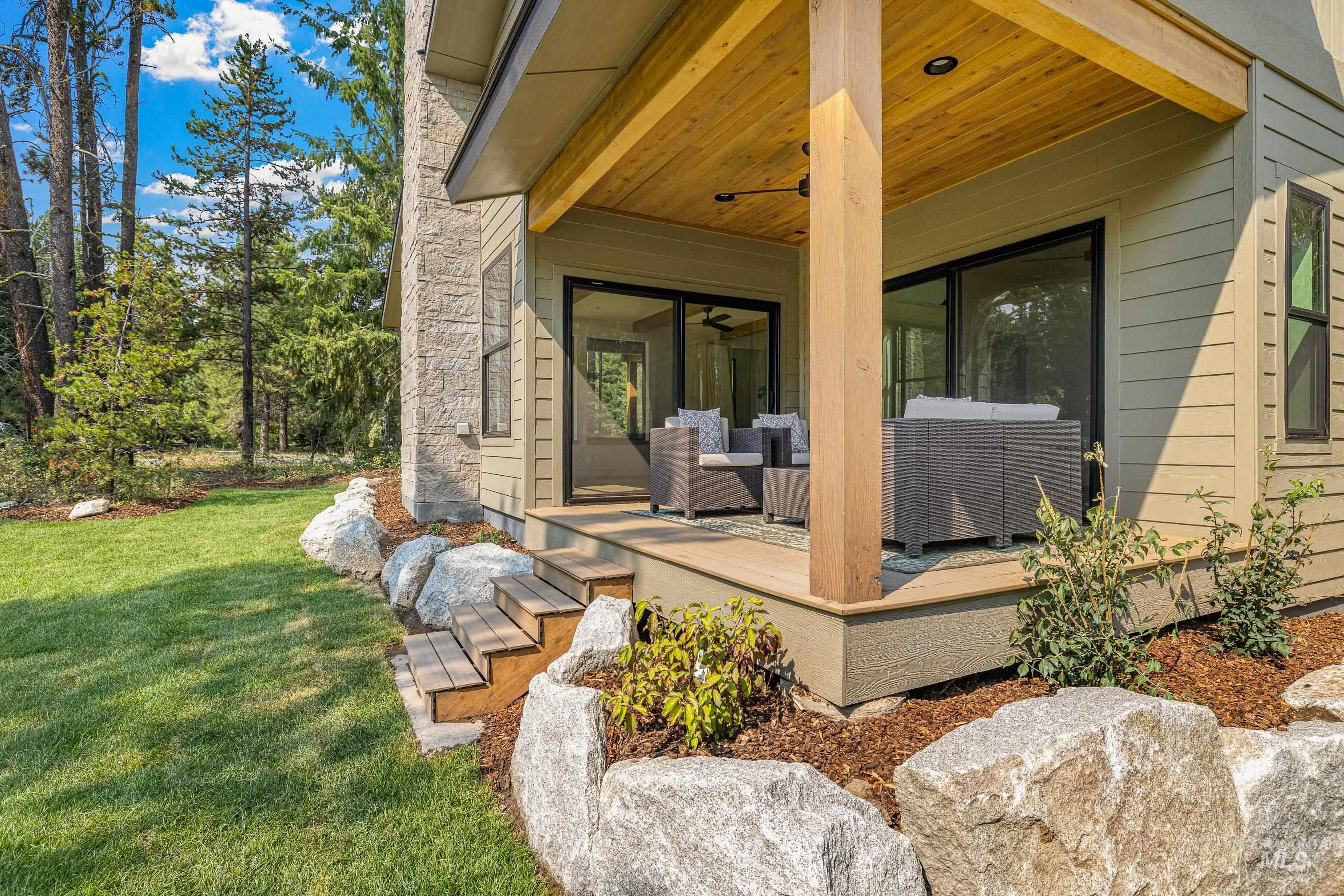 Property entrance featuring a yard, ceiling fan, and a deck