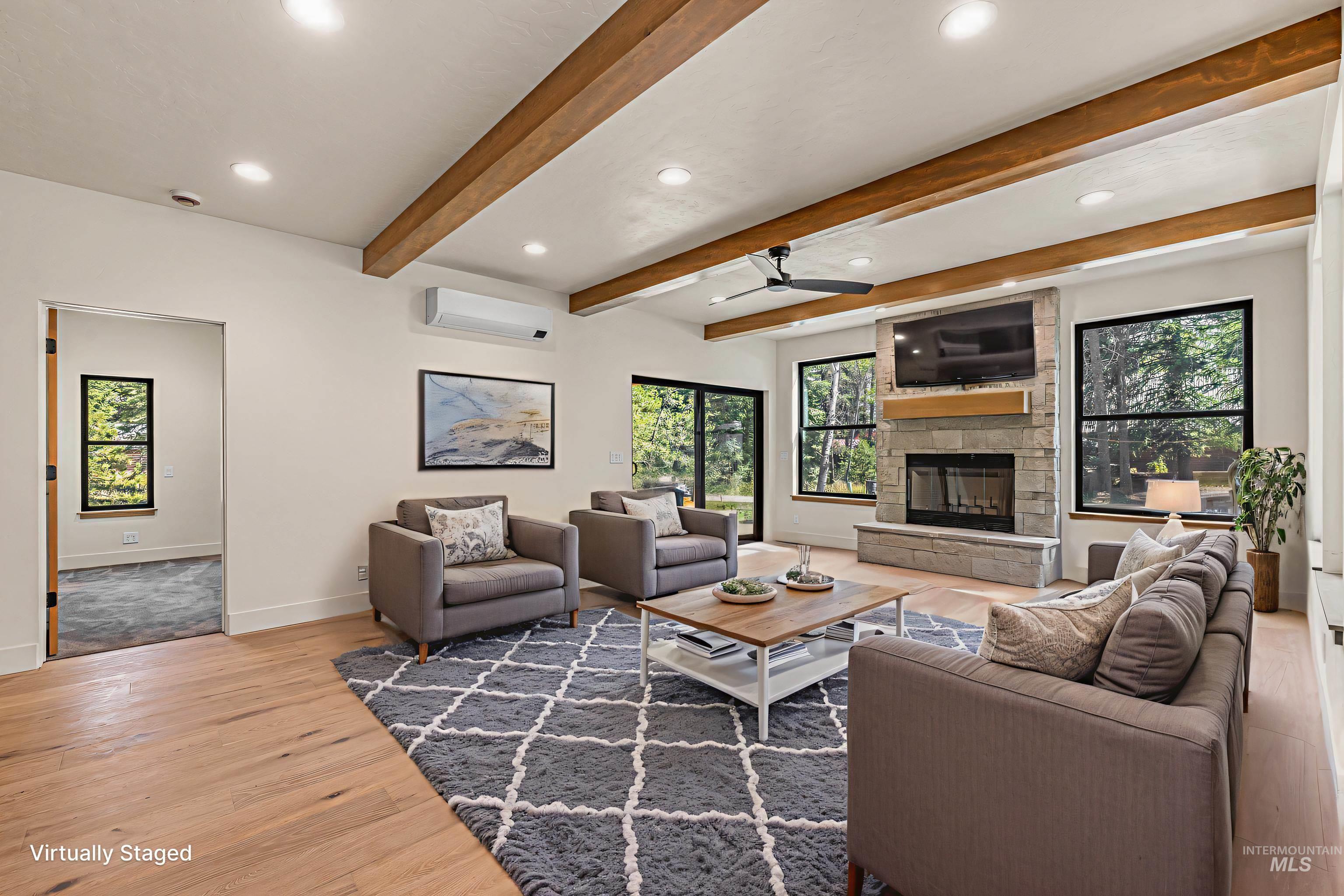 Living area with ceiling fan, recessed lighting, healthy amount of natural light, light wood-type flooring, and a stone fireplace