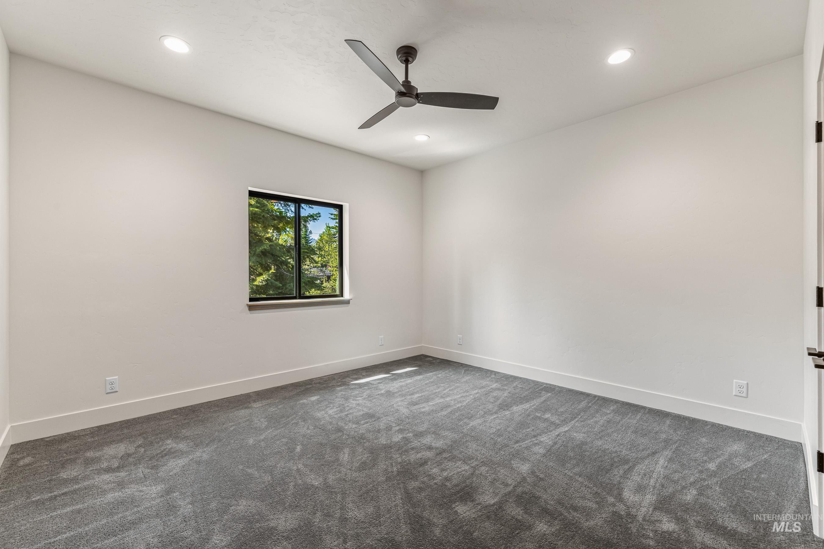 Spare room with dark carpet, recessed lighting, and a ceiling fan