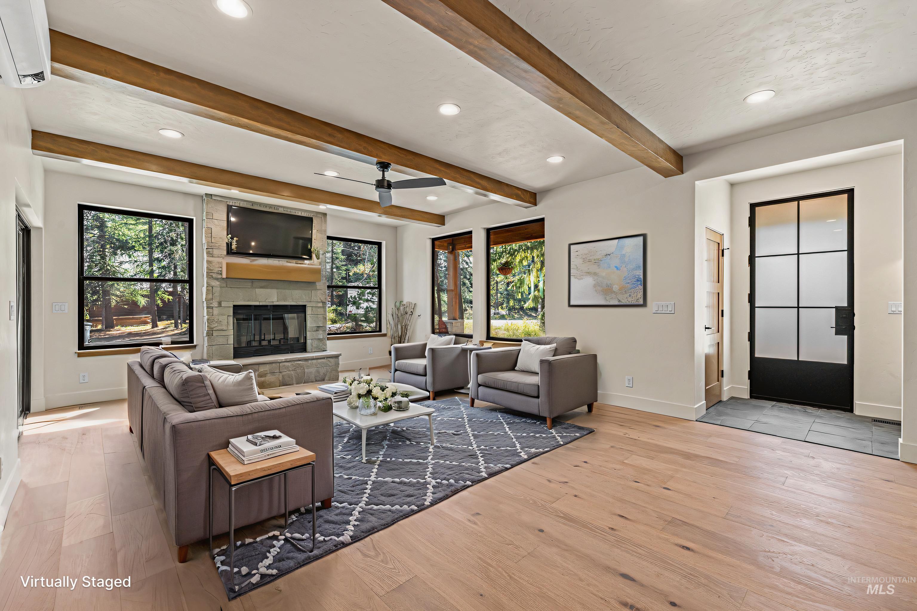 Living area featuring light wood-style floors, recessed lighting, a fireplace, a ceiling fan, and beam ceiling