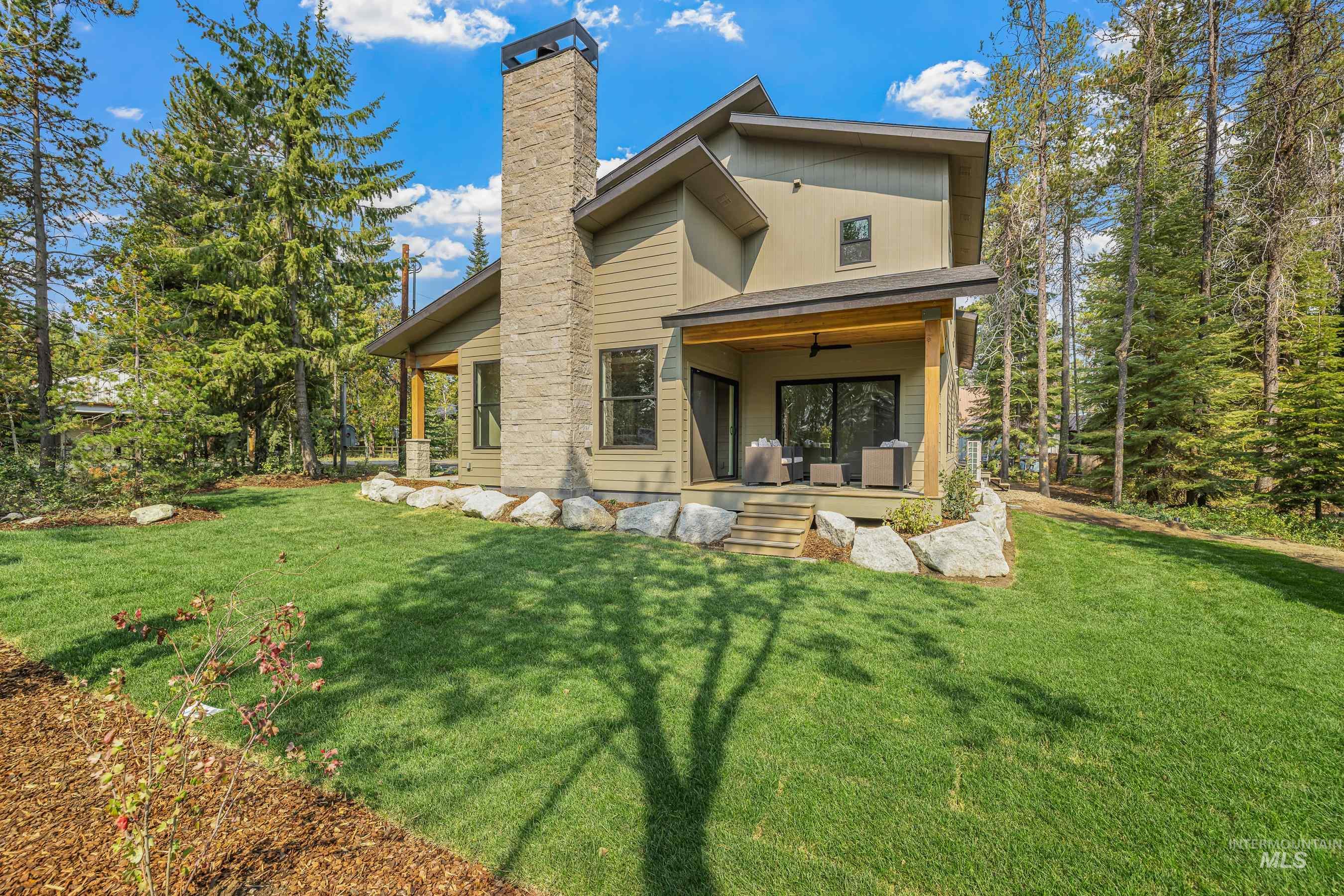 Rear view of property with a yard, a patio area, a chimney, and a ceiling fan