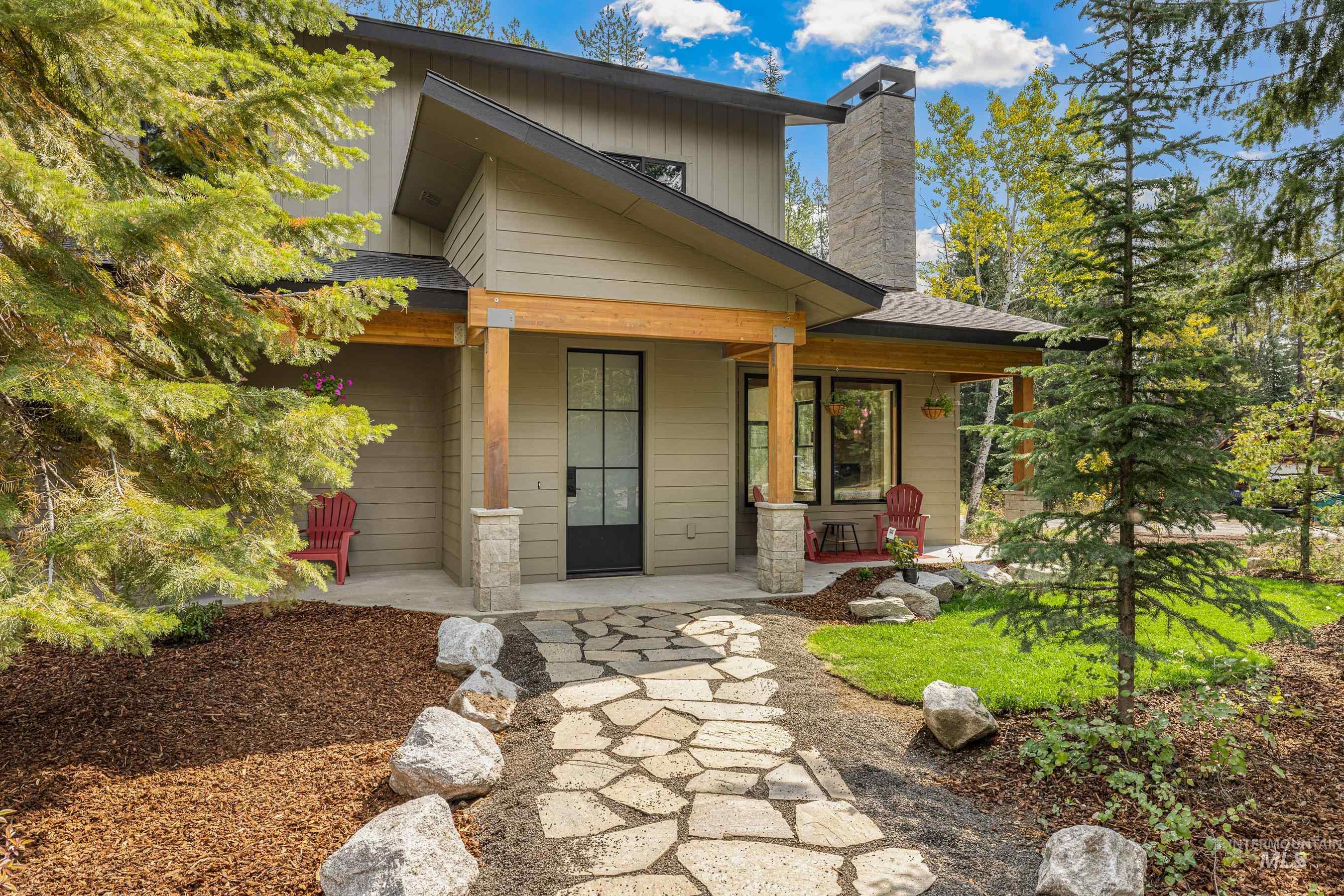 View of front of home with a chimney and a porch