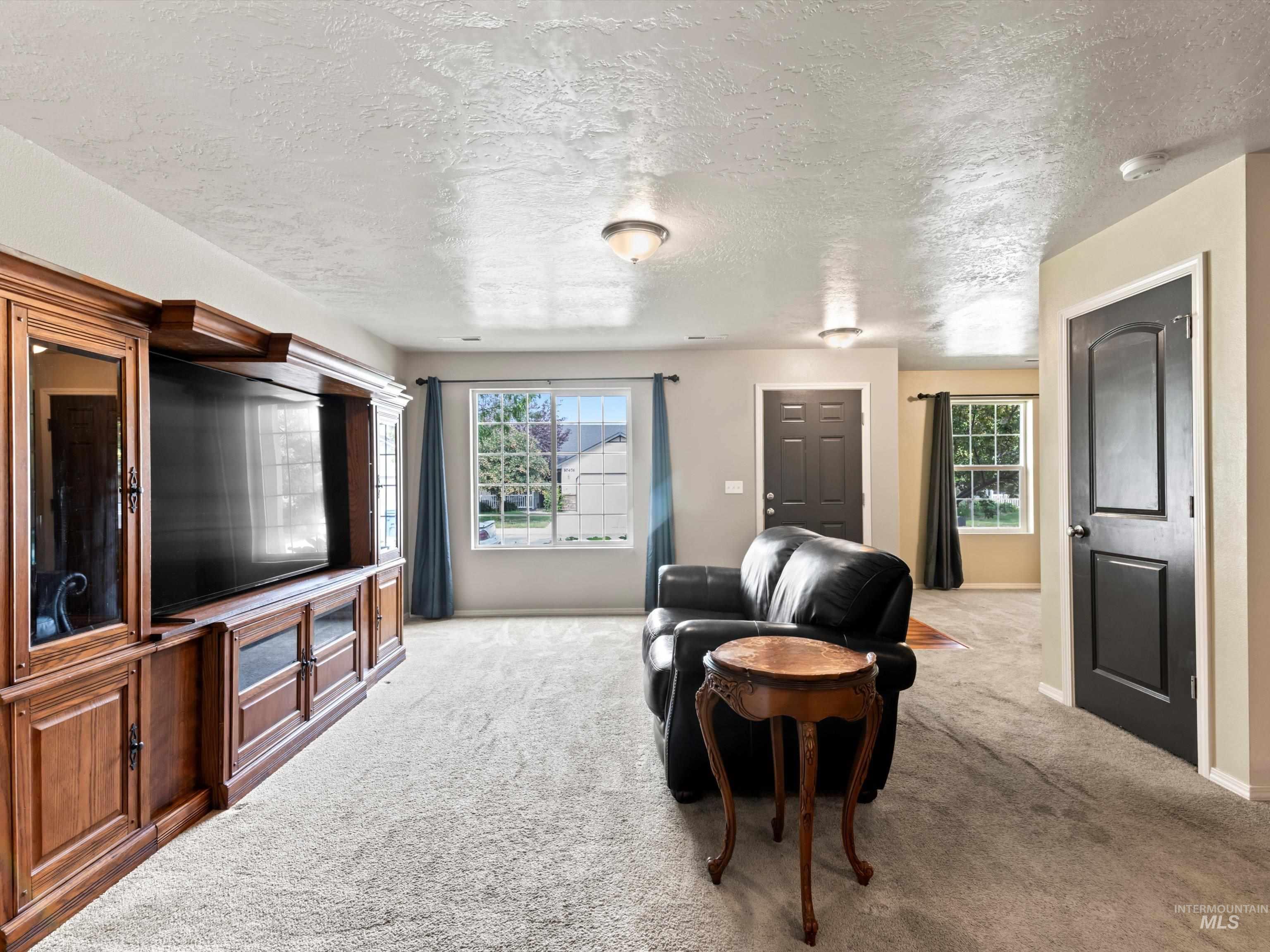 Living room with light carpet and a textured ceiling