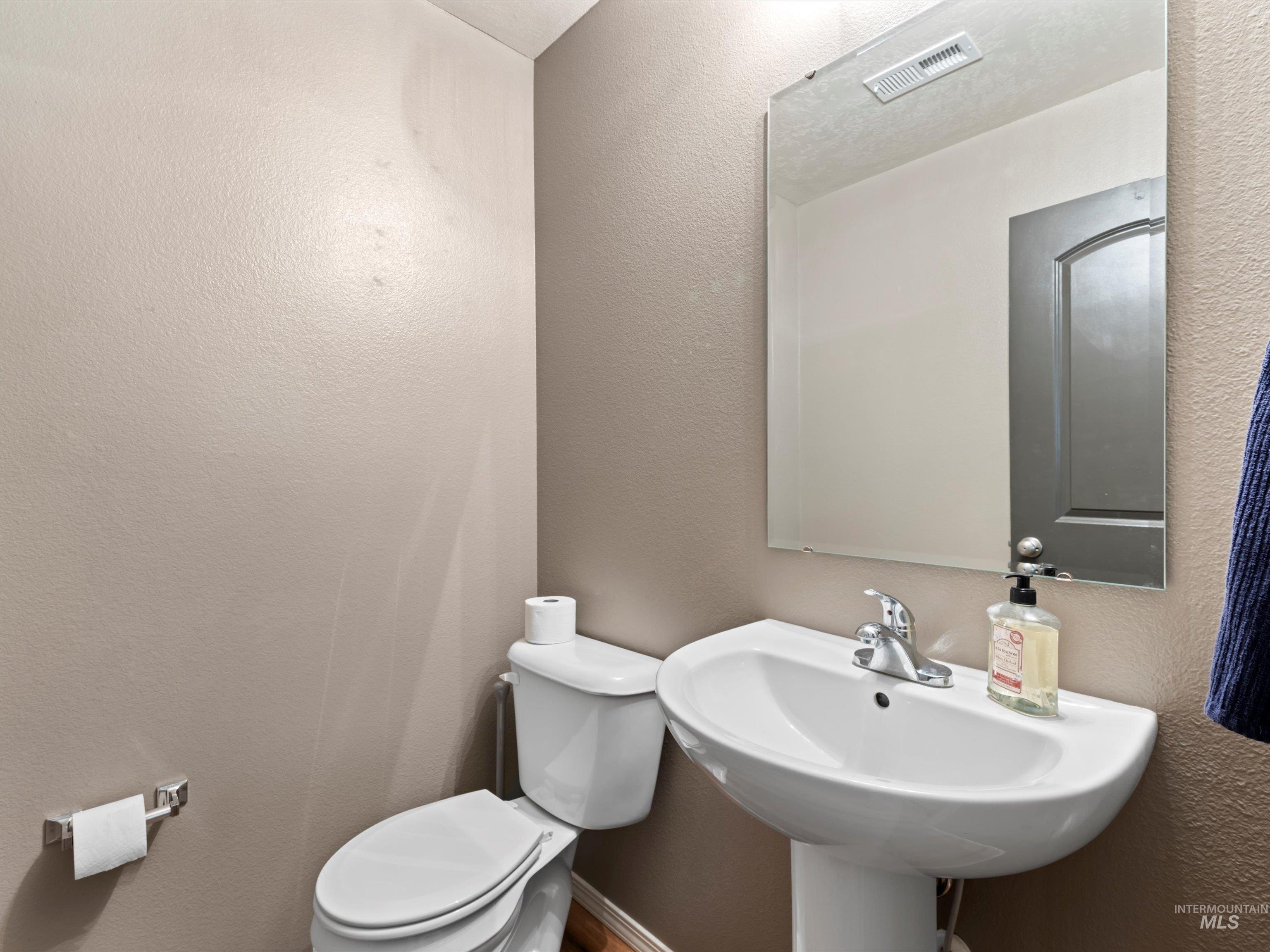Bathroom with a textured wall and toilet