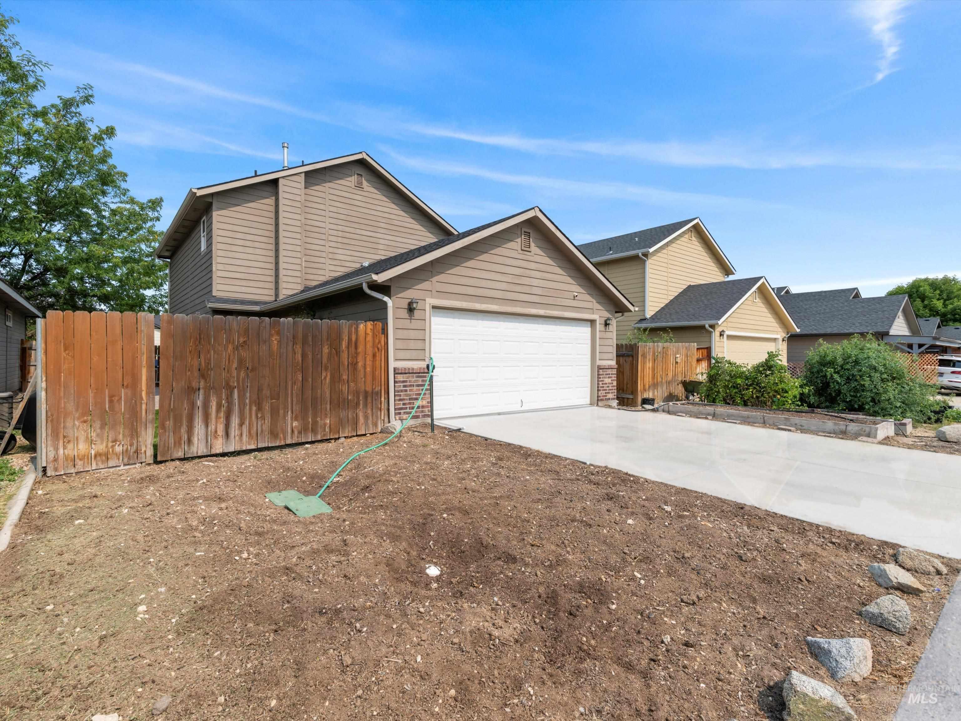 View of front of house featuring driveway, brick siding, and a garage