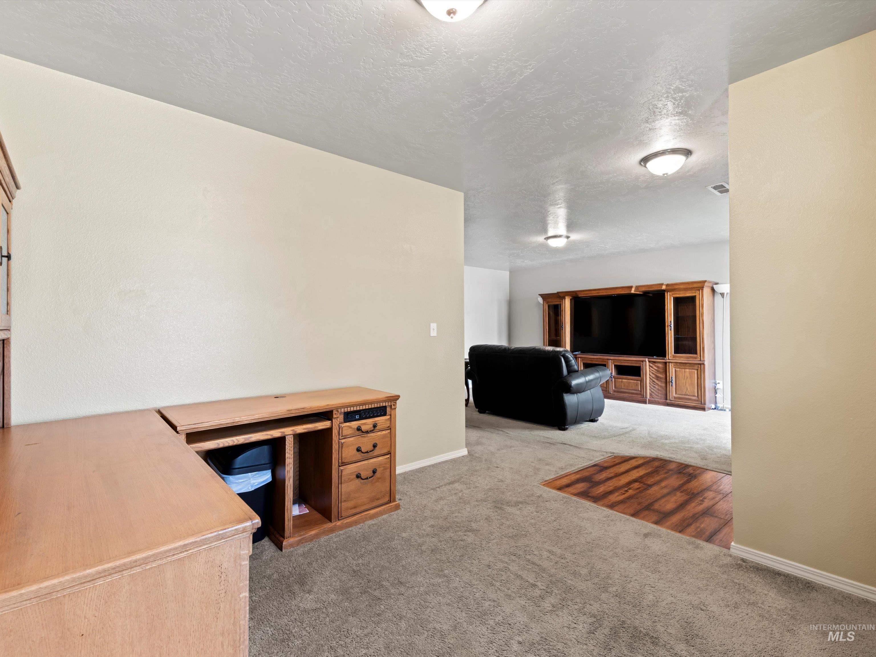 Unfurnished office with light carpet and a textured ceiling