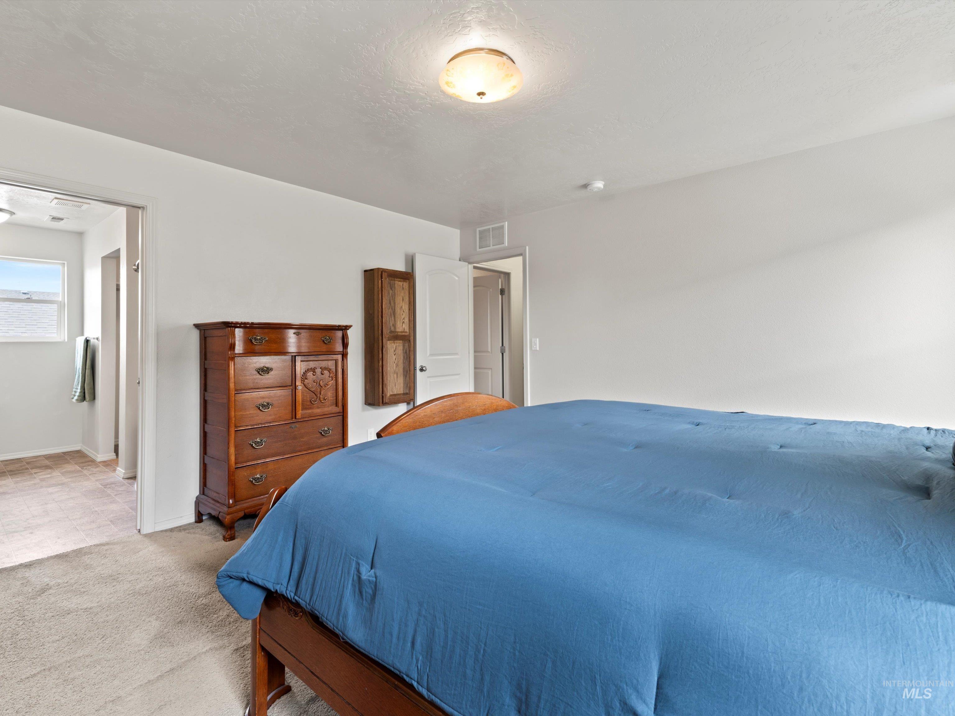 Bedroom with carpet floors and a textured ceiling