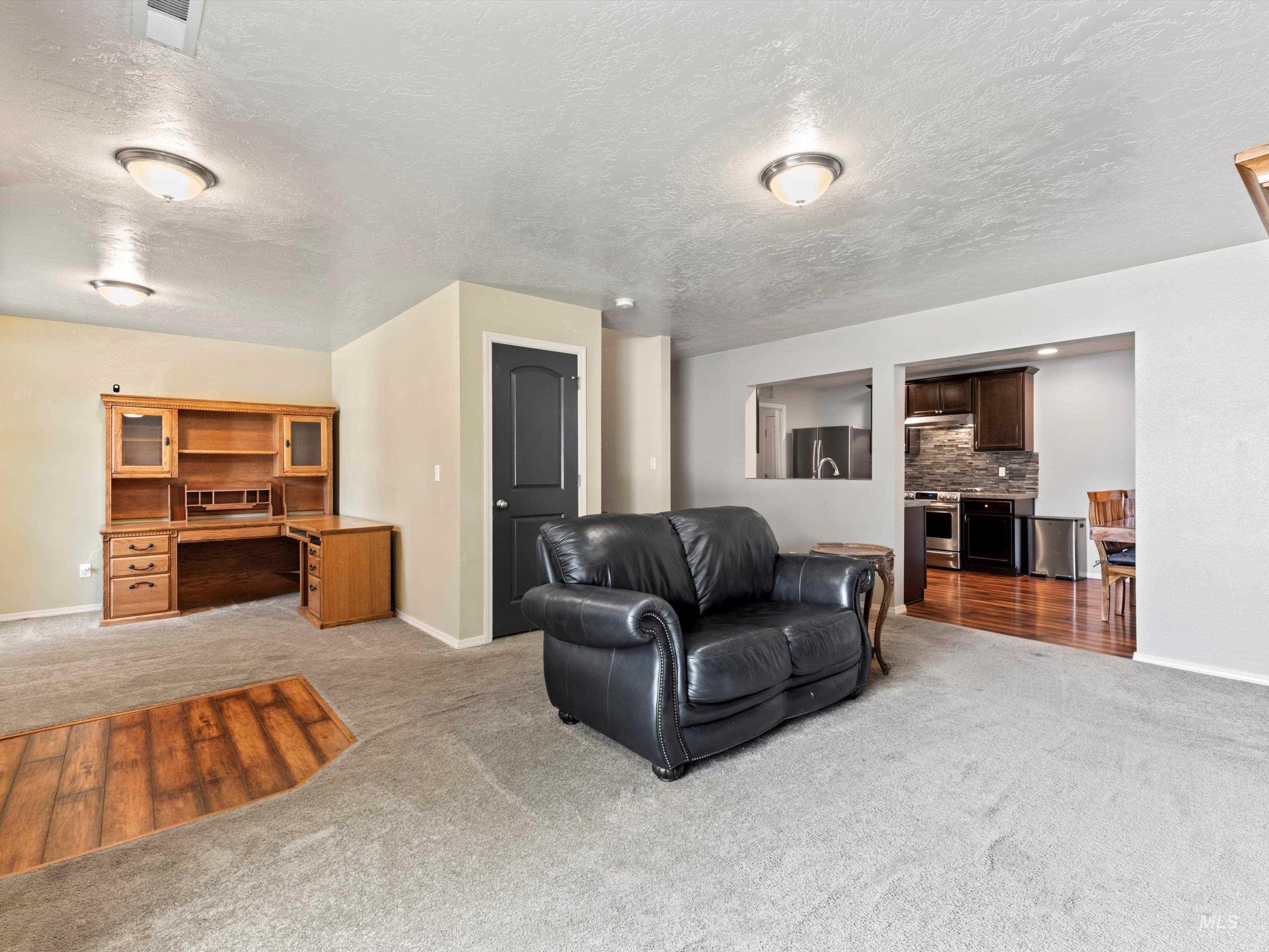 Living room featuring light colored carpet and a textured ceiling
