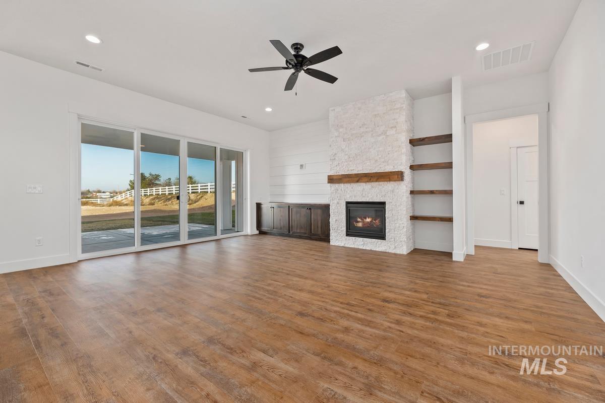 Unfurnished living room with a fireplace, light wood-style floors, a ceiling fan, and recessed lighting