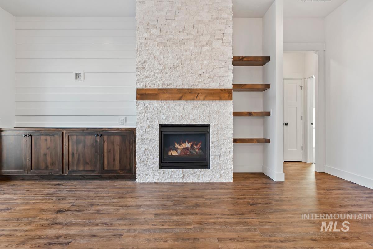 Unfurnished living room featuring dark wood-style floors and a fireplace
