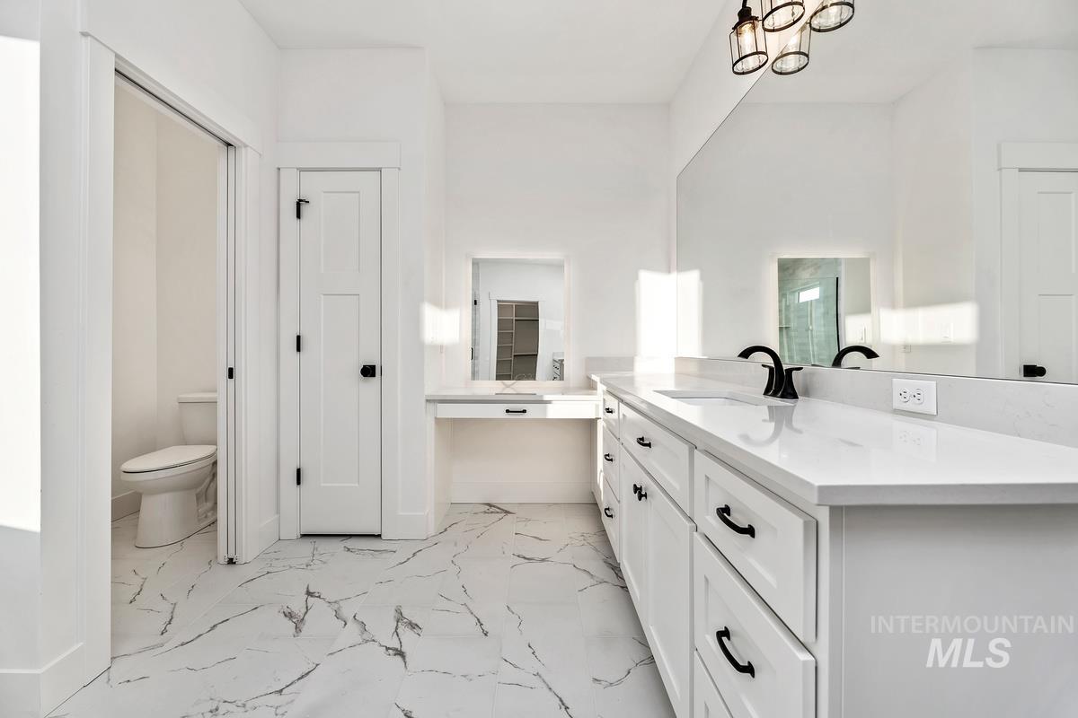 Bathroom featuring vanity and light marble finish flooring