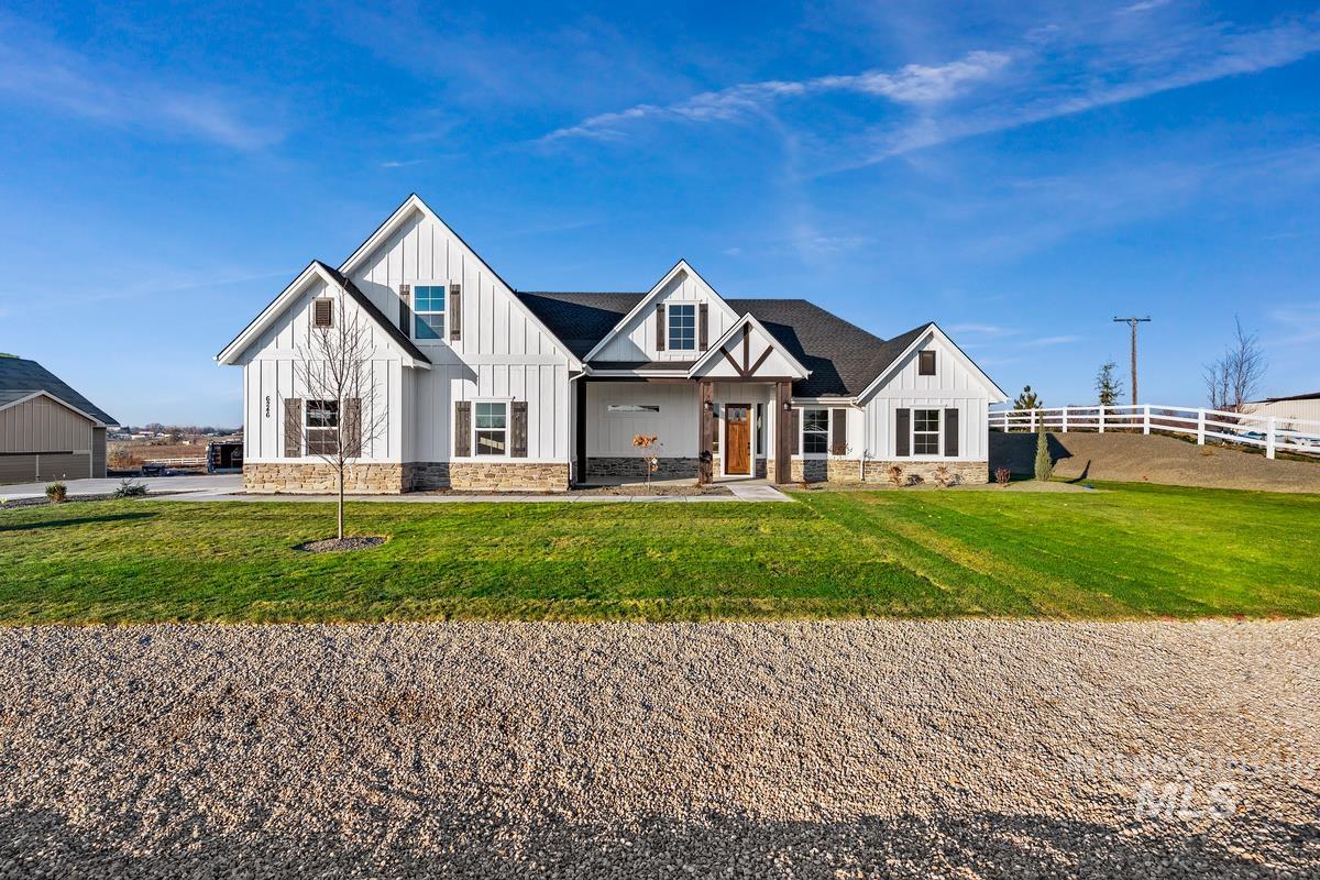 Modern inspired farmhouse featuring board and batten siding, covered porch, and stone siding