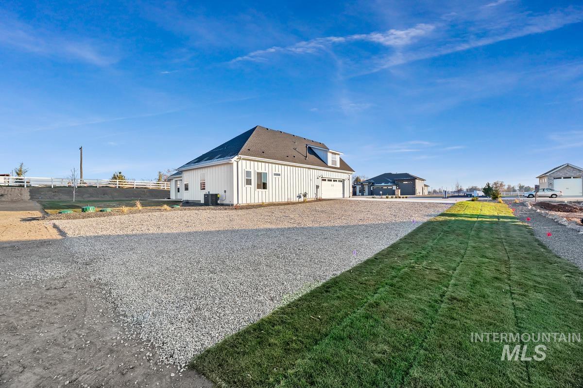 View of home's exterior featuring a garage, driveway, a yard, a residential view, and roof with shingles