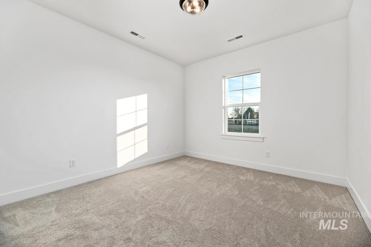 Empty room with light carpet and baseboards