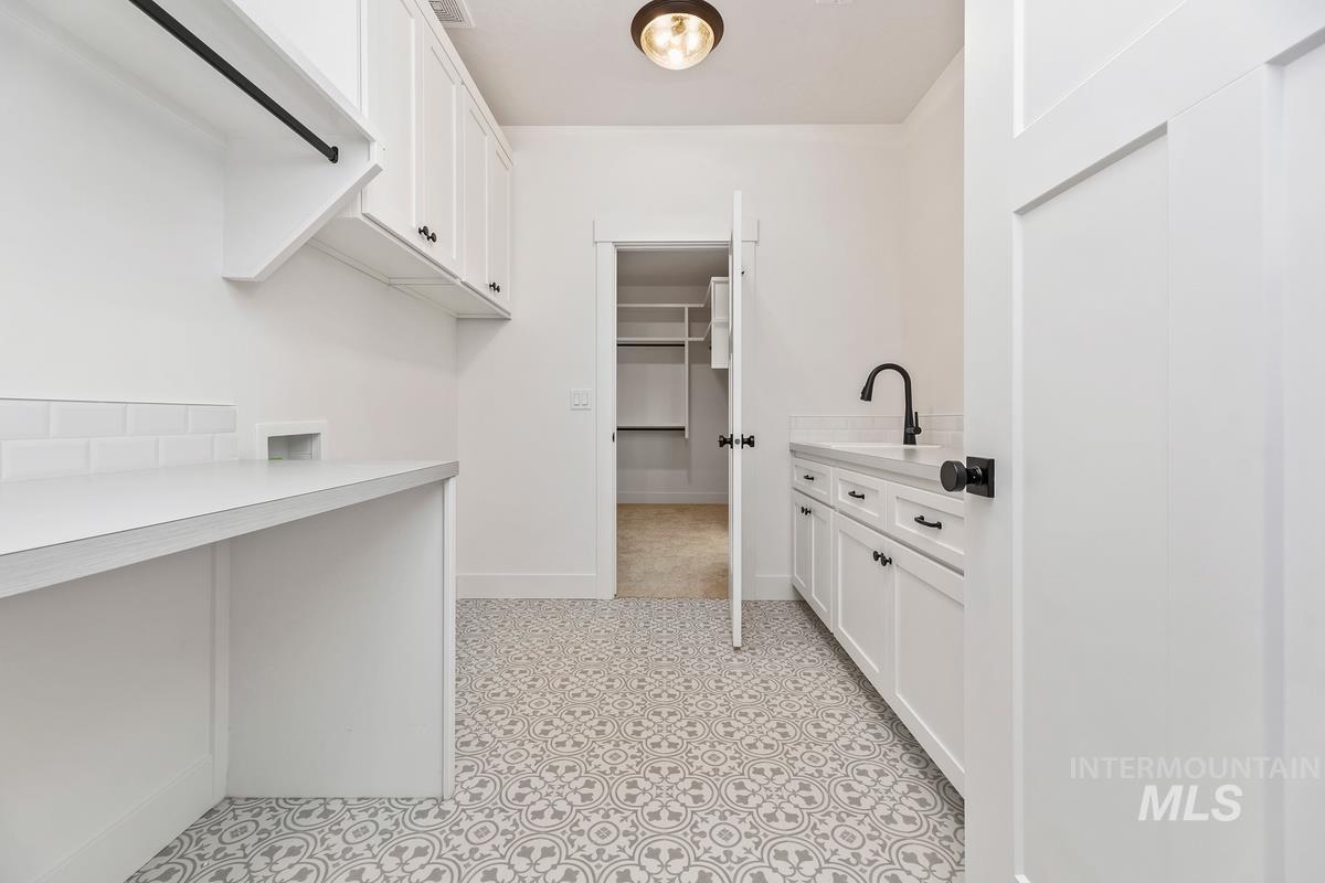 Walk in closet featuring light flooring and a sink