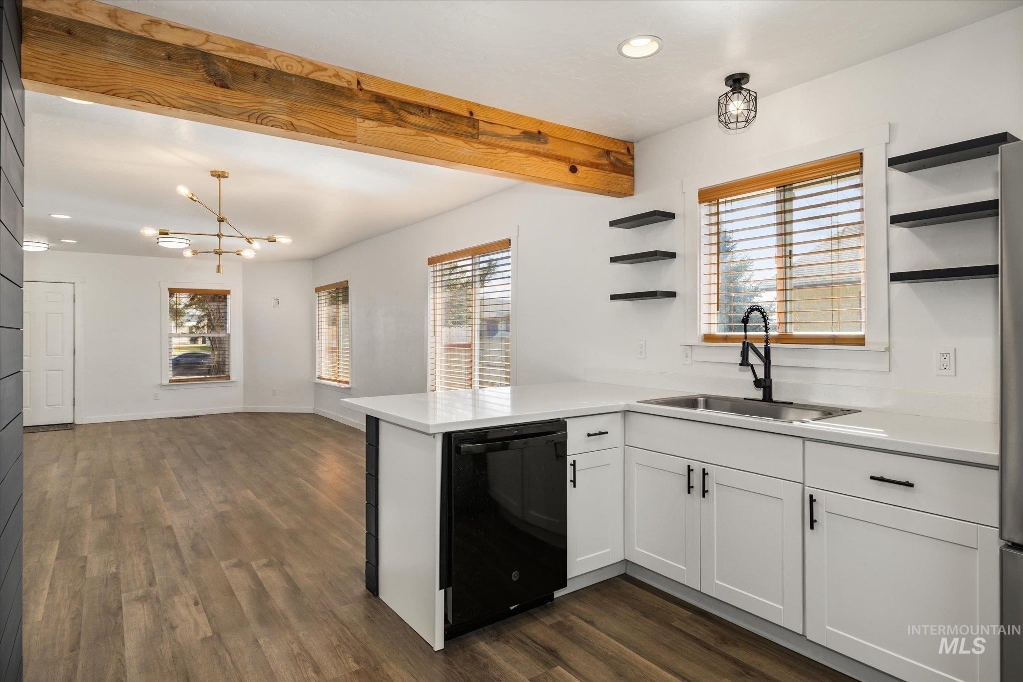 Kitchen featuring open shelves, a peninsula, dishwasher, white cabinetry, and suspended lighting