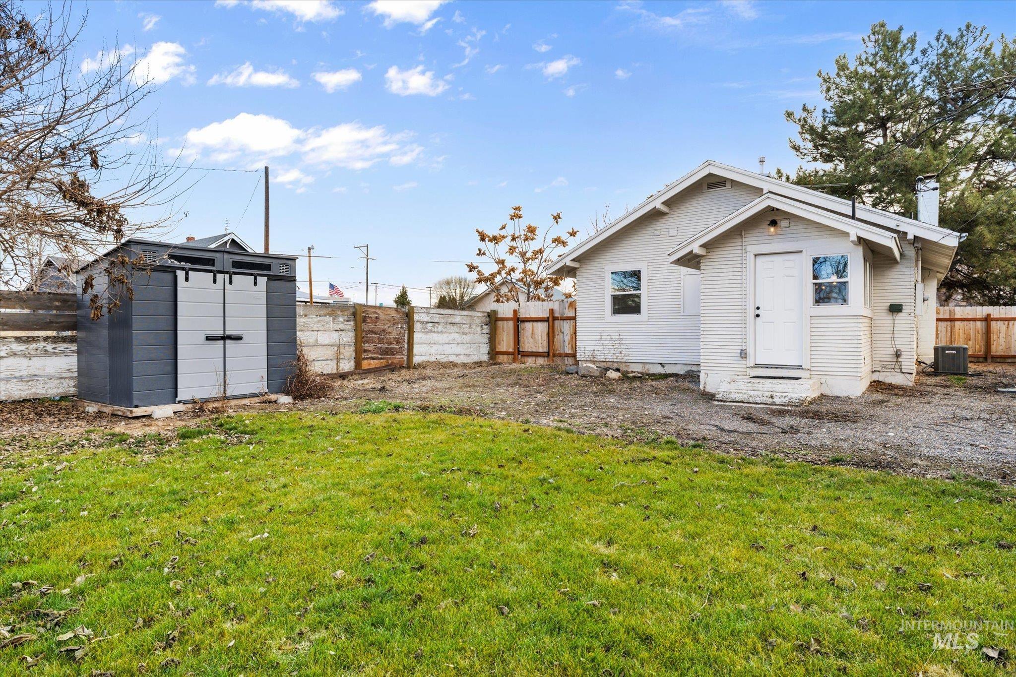 Fenced backyard featuring a storage shed