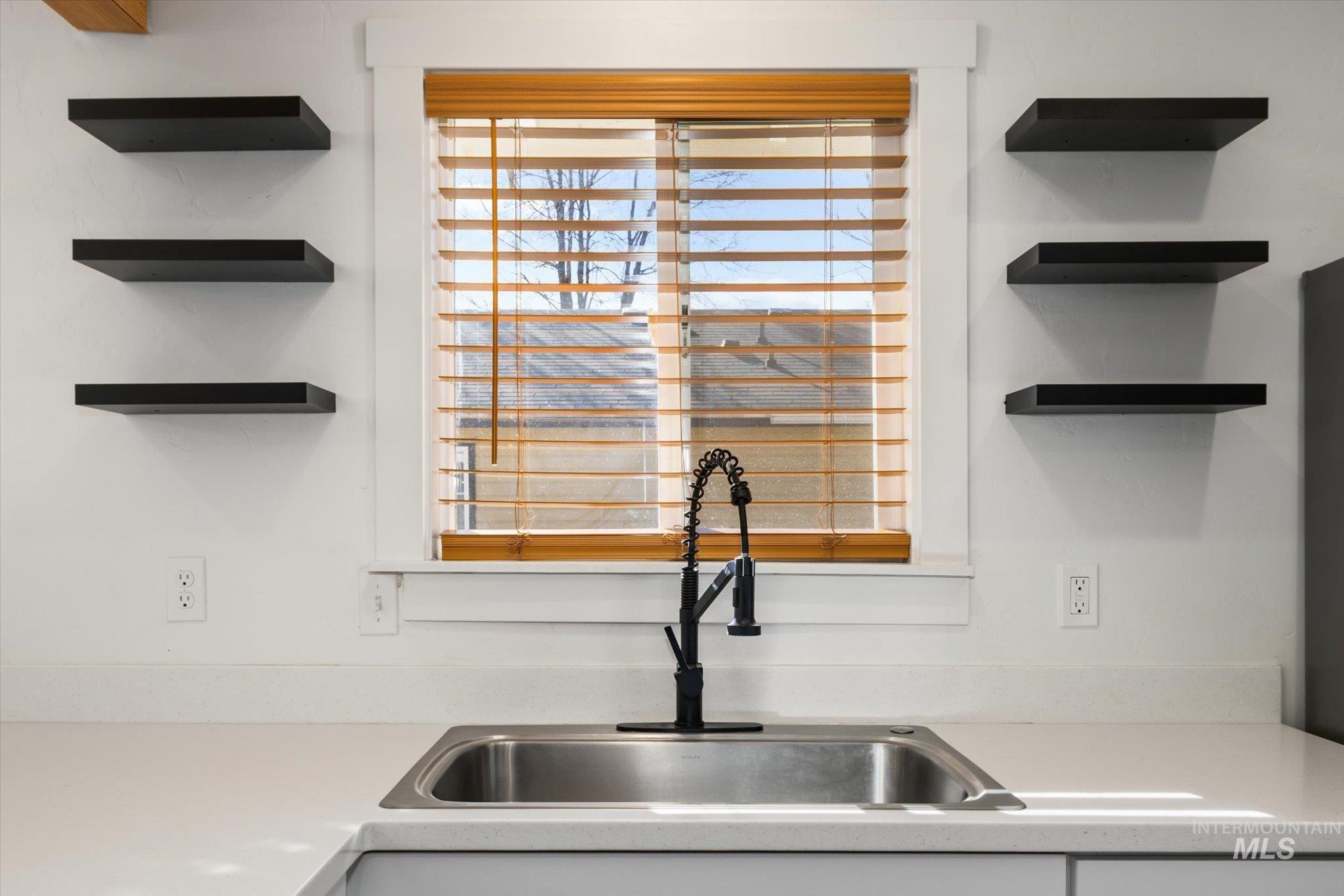 Kitchen view of open shelves and a sink