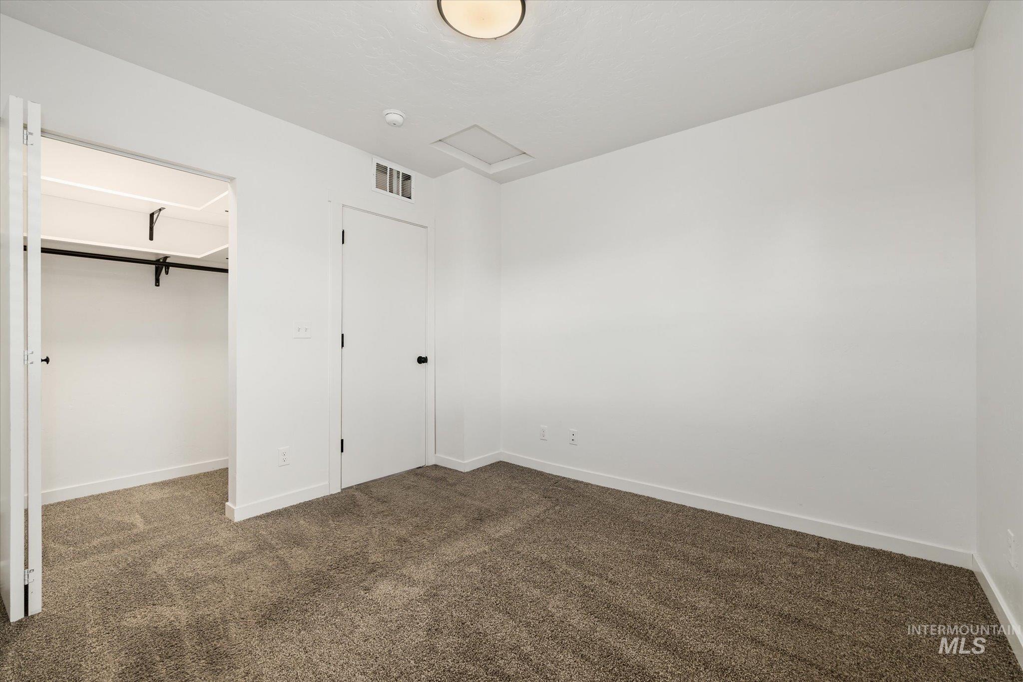 Unfurnished bedroom featuring carpet and a spacious closet
