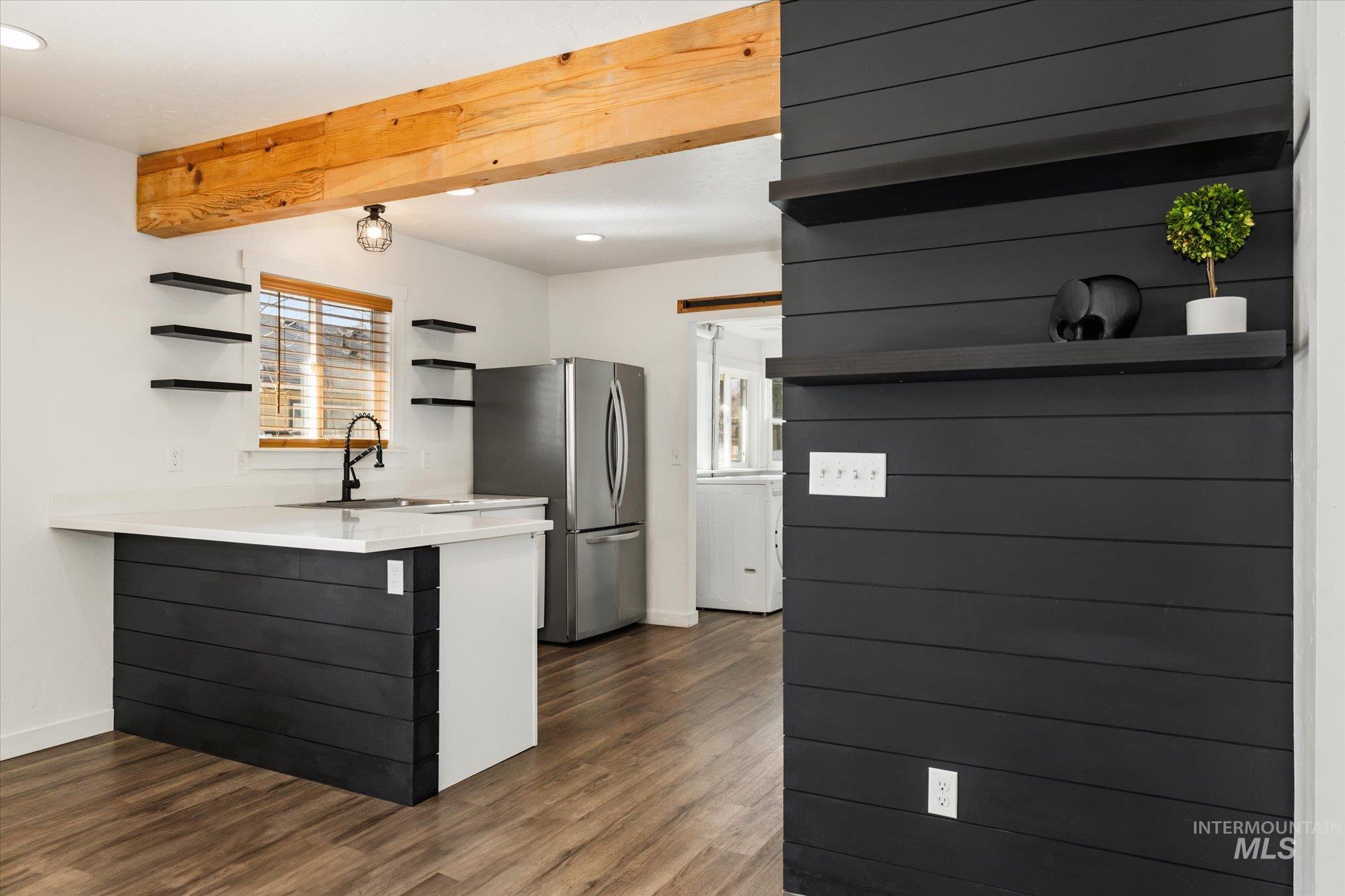 Kitchen featuring open shelves, light countertops, recessed lighting, freestanding refrigerator, and a peninsula