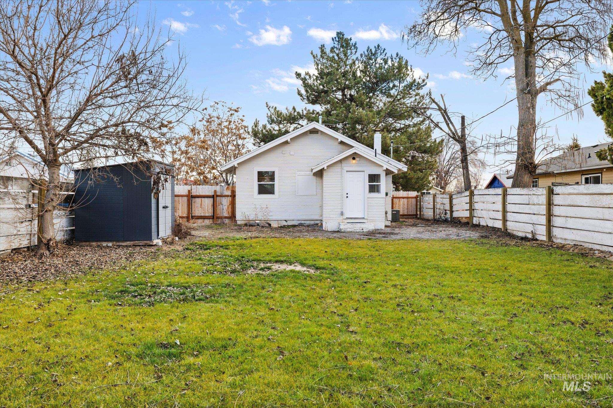 Back of house featuring a fenced backyard and a storage shed